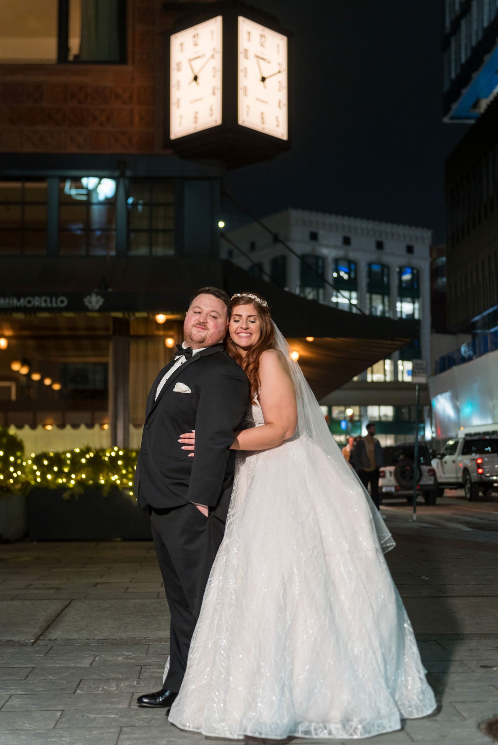 A bride and groom pose in front of San Morello on Woodward in Detroit.