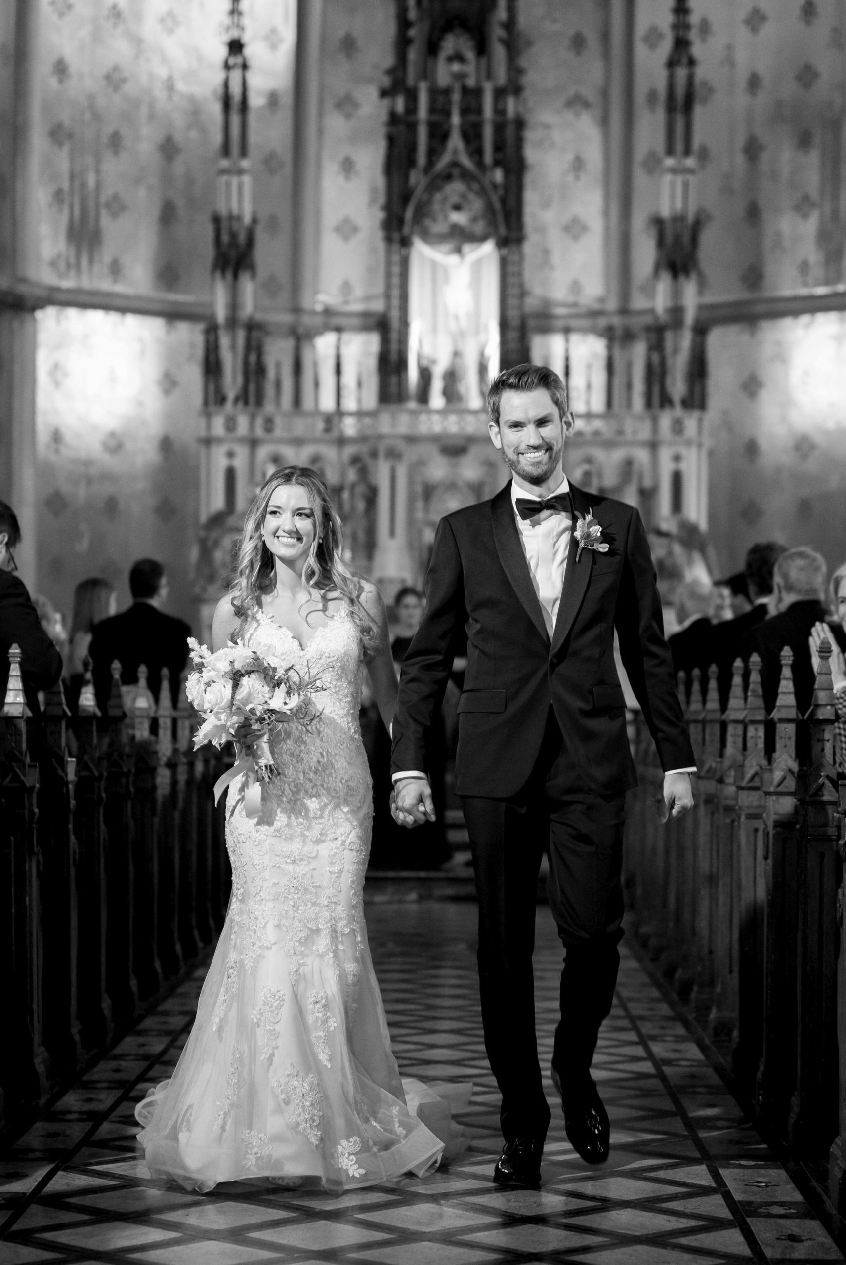 A bride and groom walk down the aisle at St. Anne de Detroit. 
