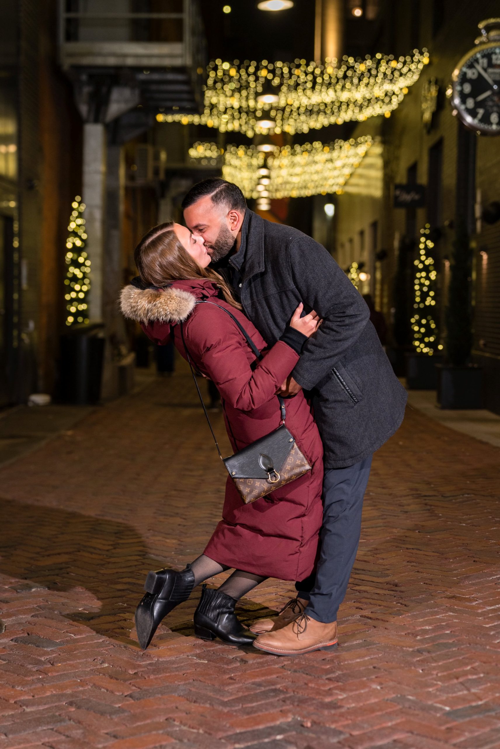 A couple kisses after their Parker's Alley proposal at night in Detroit. 