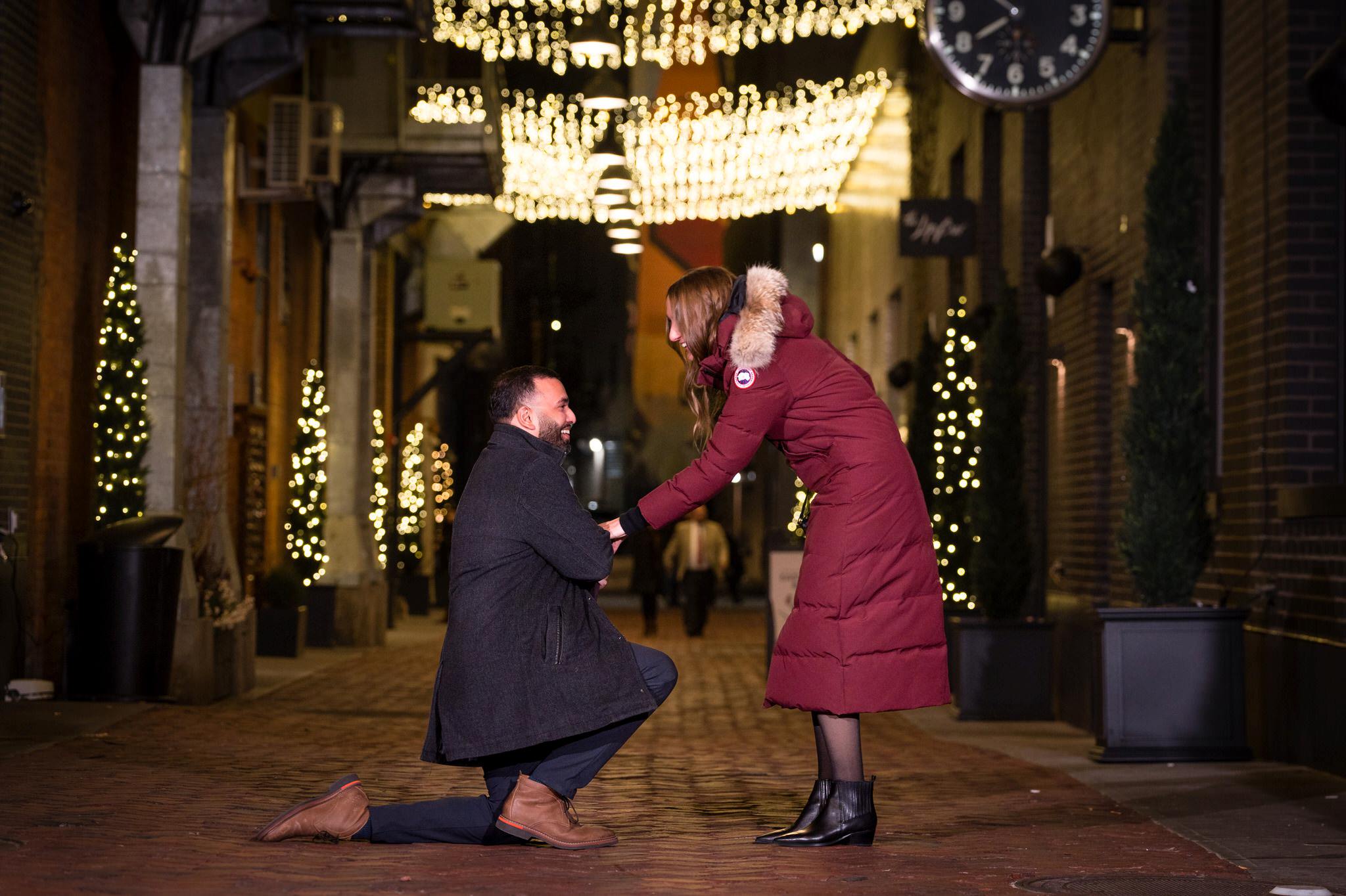 A man proposes to his girlfriend at night in Parker's Alley Detroit. 