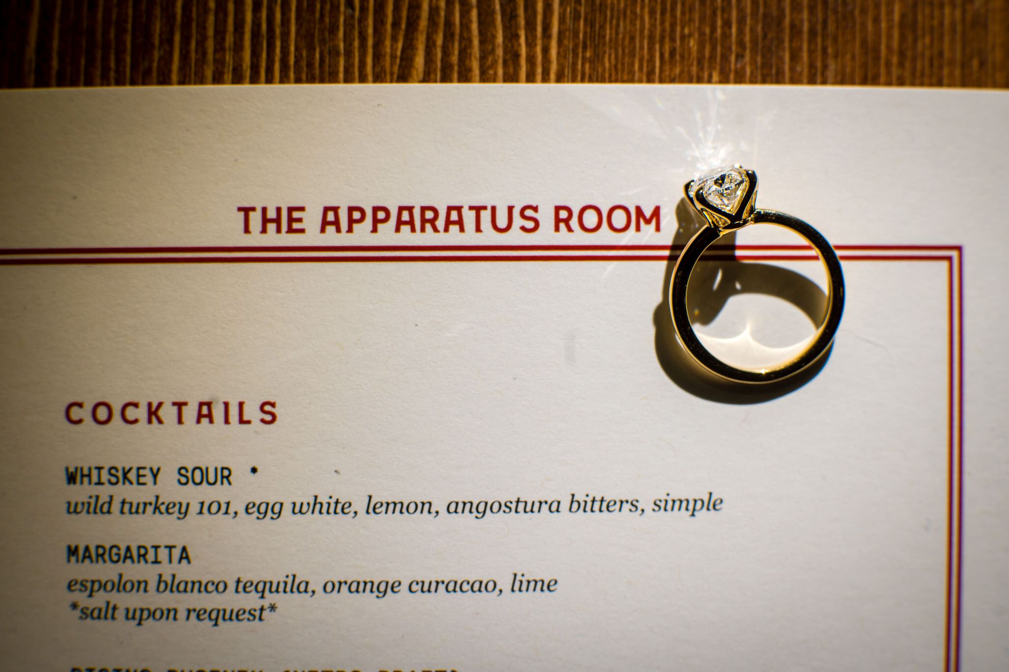 A diamond engagement ring sits on top of the Apparatus Room menu. 