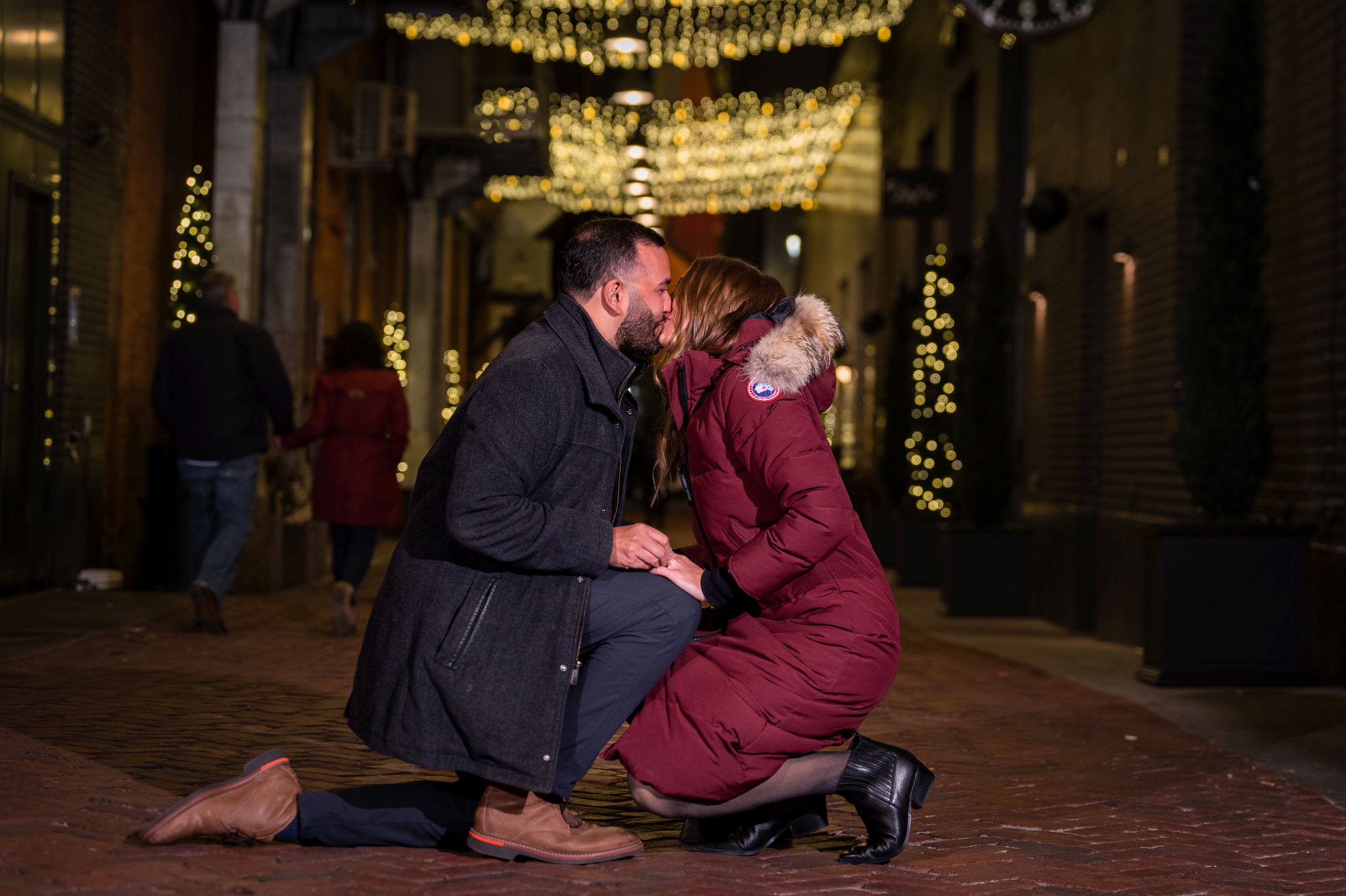 A couple kisses at their Parker's Alley proposal at night in Detroit.  