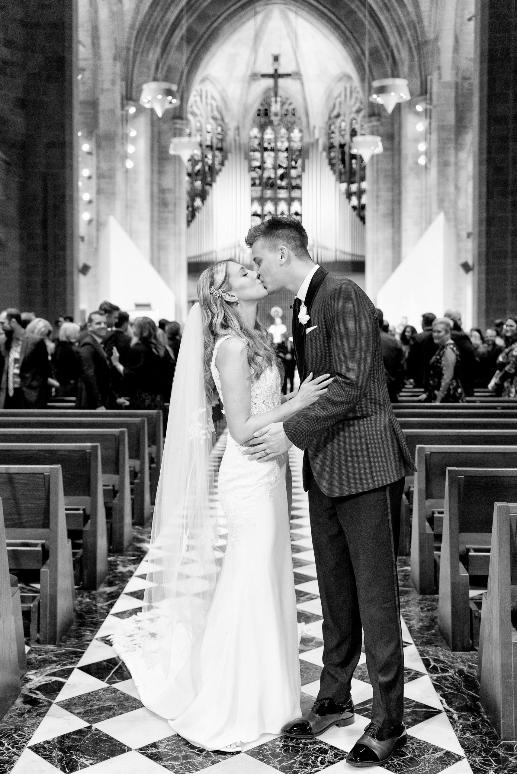 Newlyweds kiss at the end of the aisle during their the Cathedral of the Most Blessed Sacrament wedding ceremony.  