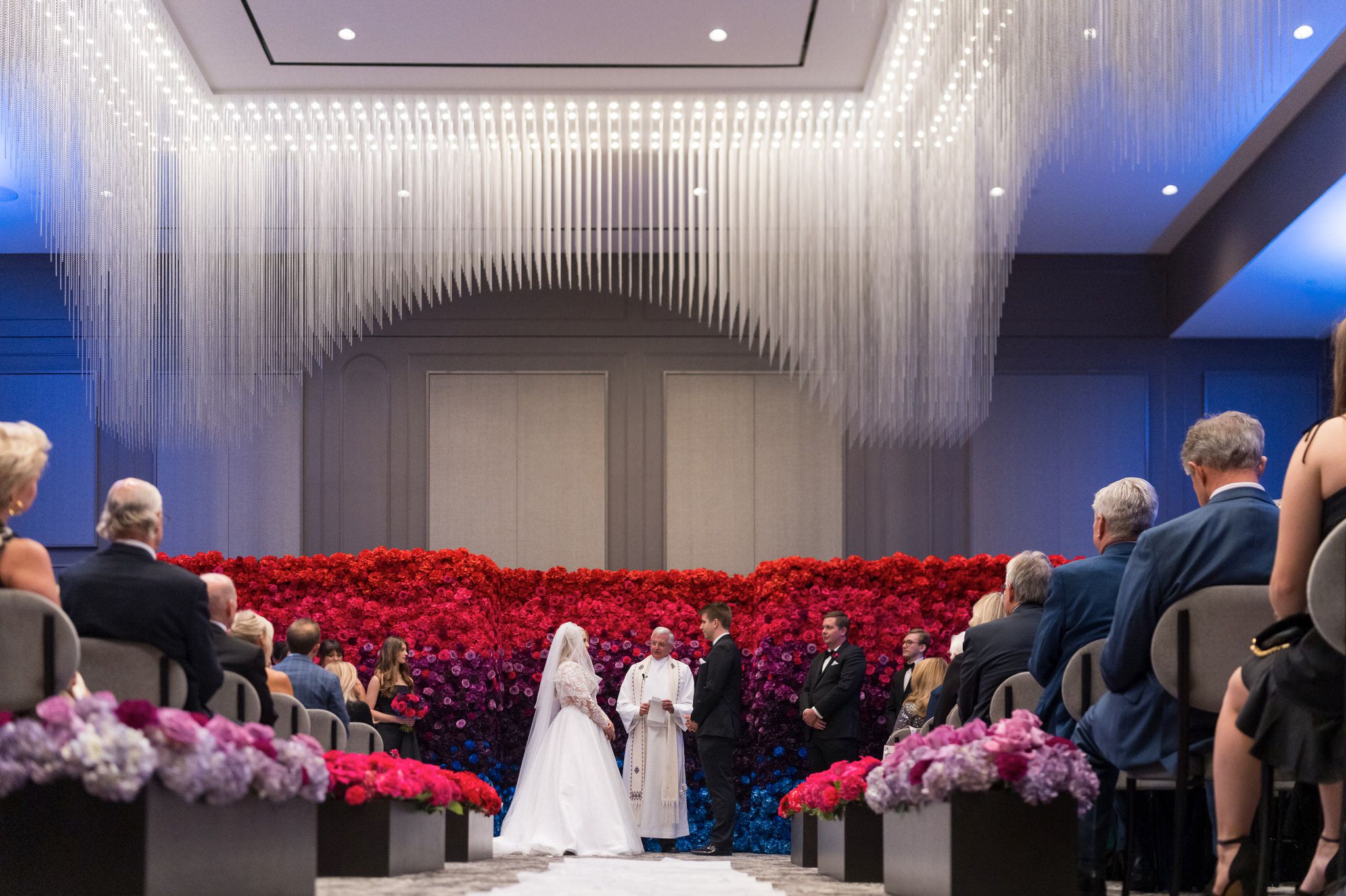 A bride and groom stand at the front of the aisle during their Daxton Hotel wedding.  