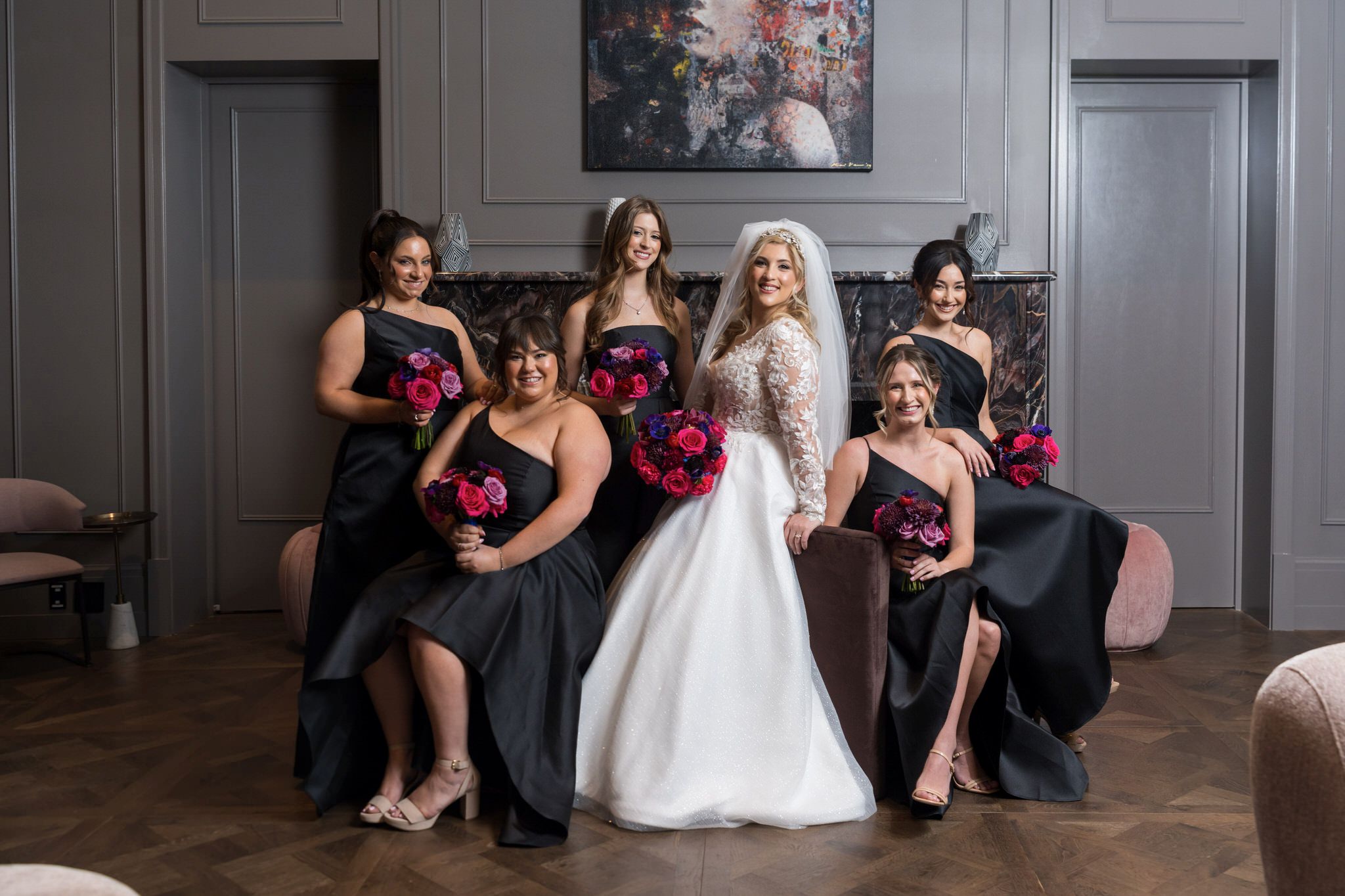 A bride poses with her bridesmaids on her wedding day at the Daxton Hotel in Birmingham, MI.  