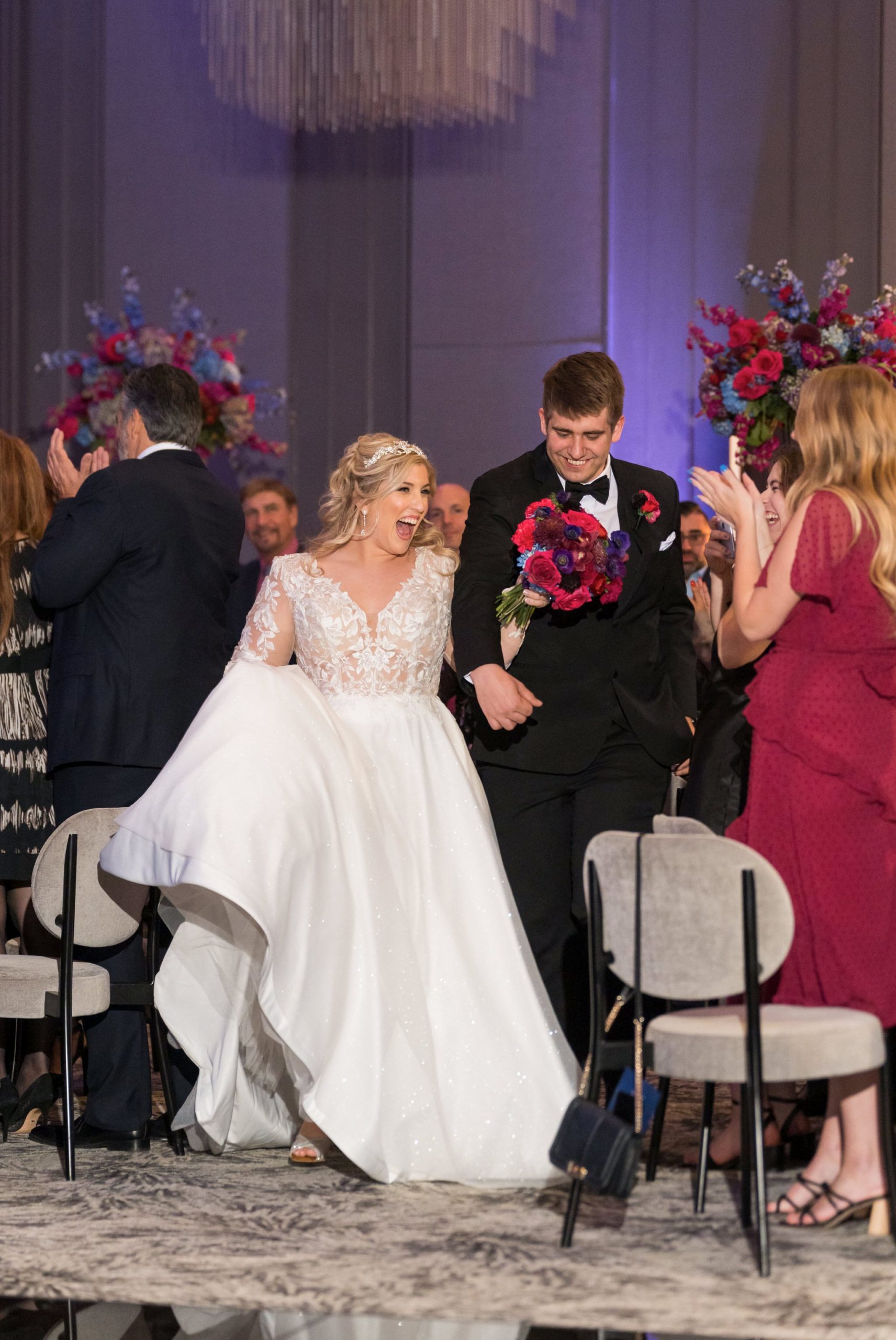A bride and groom enter into the grand ballroom of their Daxton Hotel wedding.  