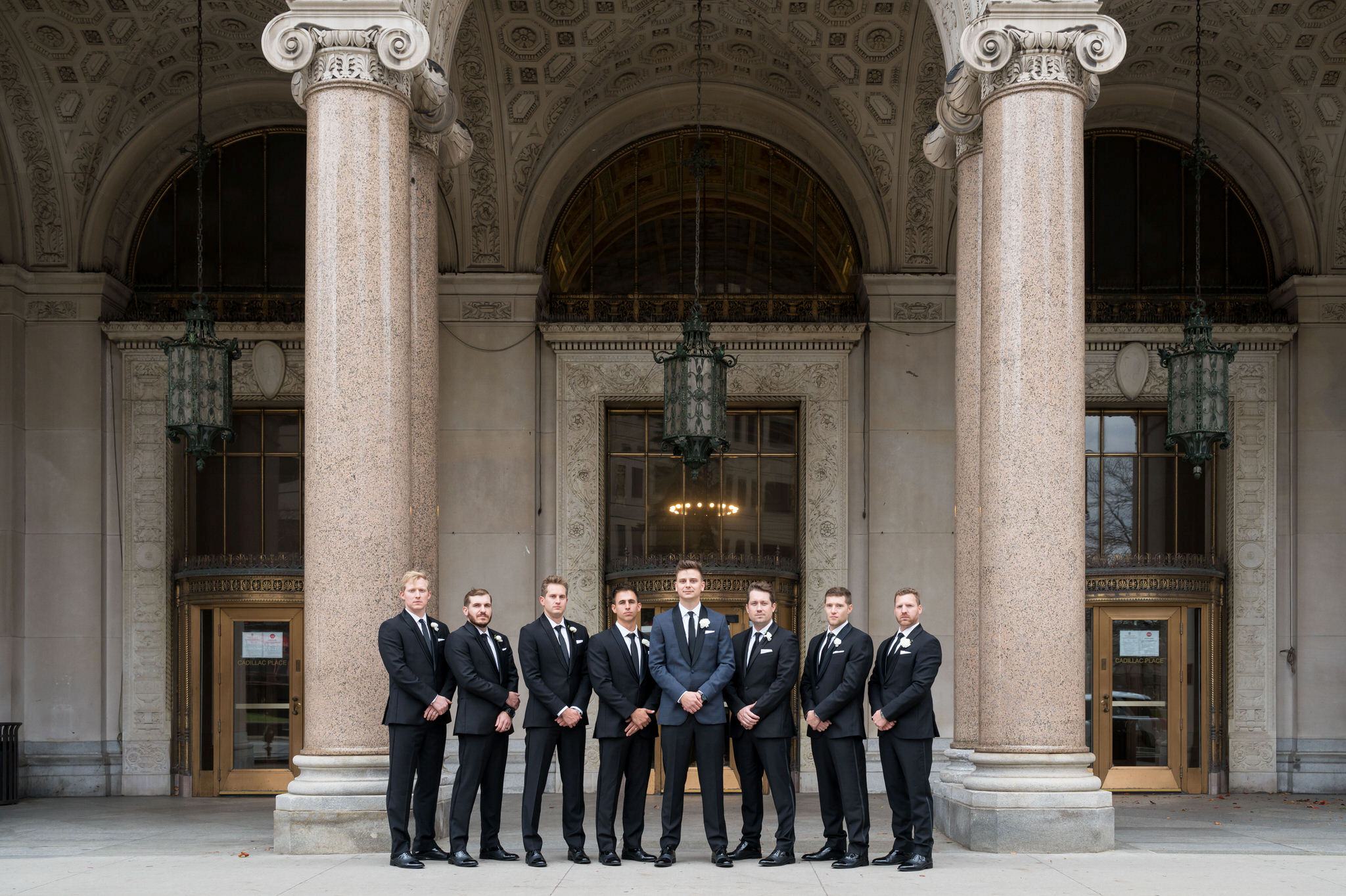 Groomsmen pose in front of the Cadillac Place apartments in Detroit, MI.   