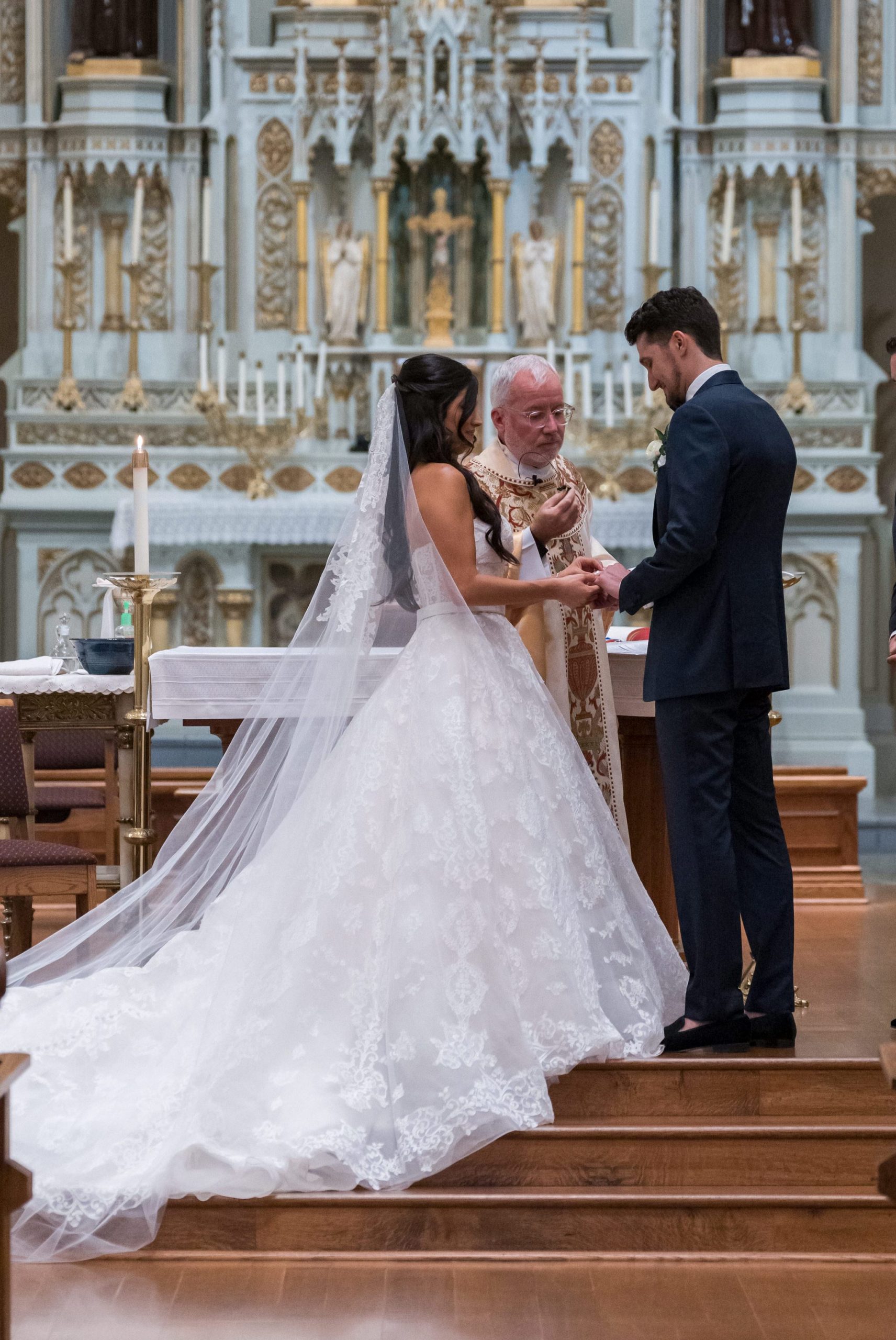 A couple exchange vows and rings on their wedding day at St. Francis Xavier church in Petoskey, MI. 