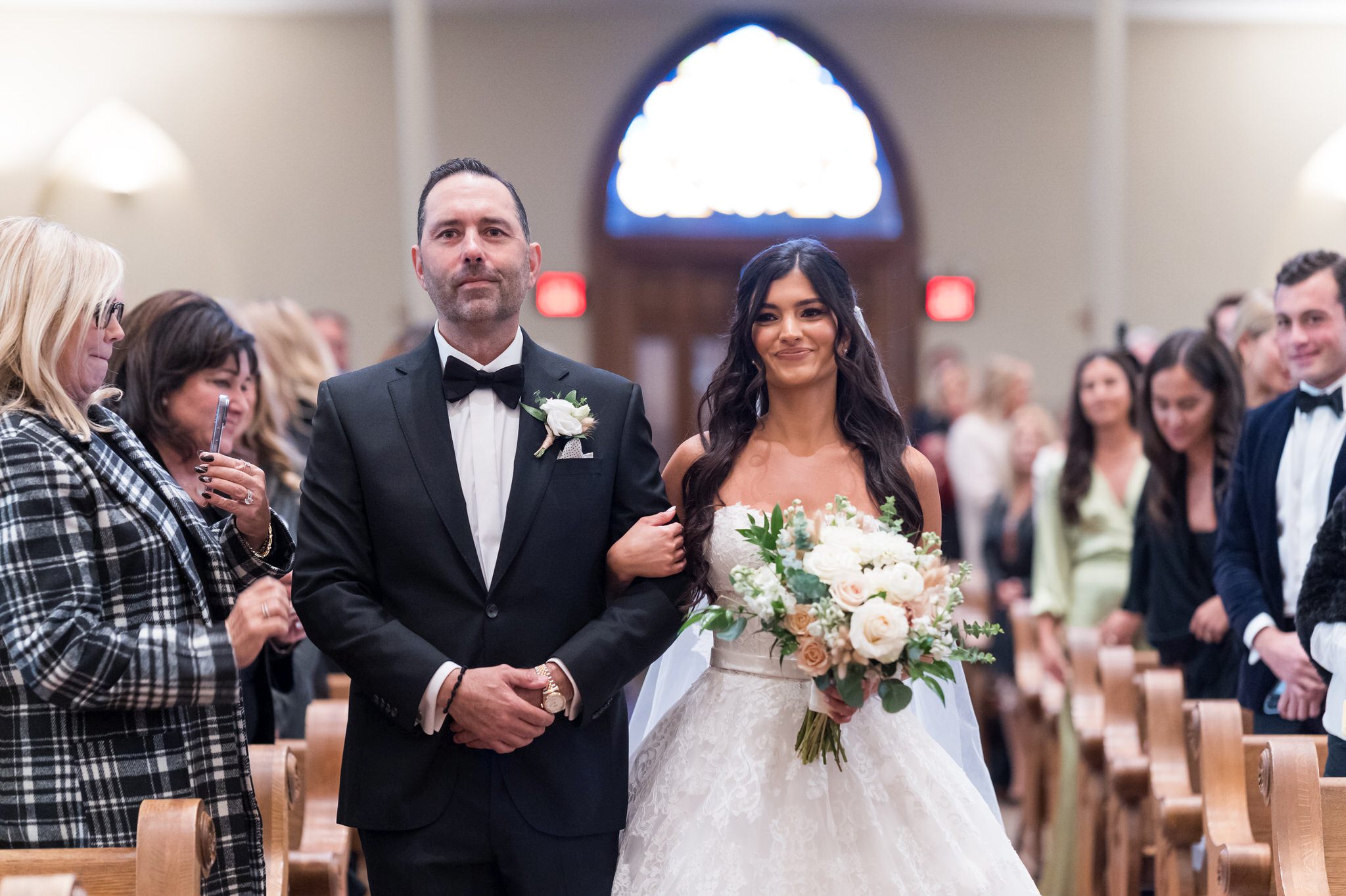 The bride walks down the aisle at St. Francis Xavier on her wedding day in downtown Petoskey.  
