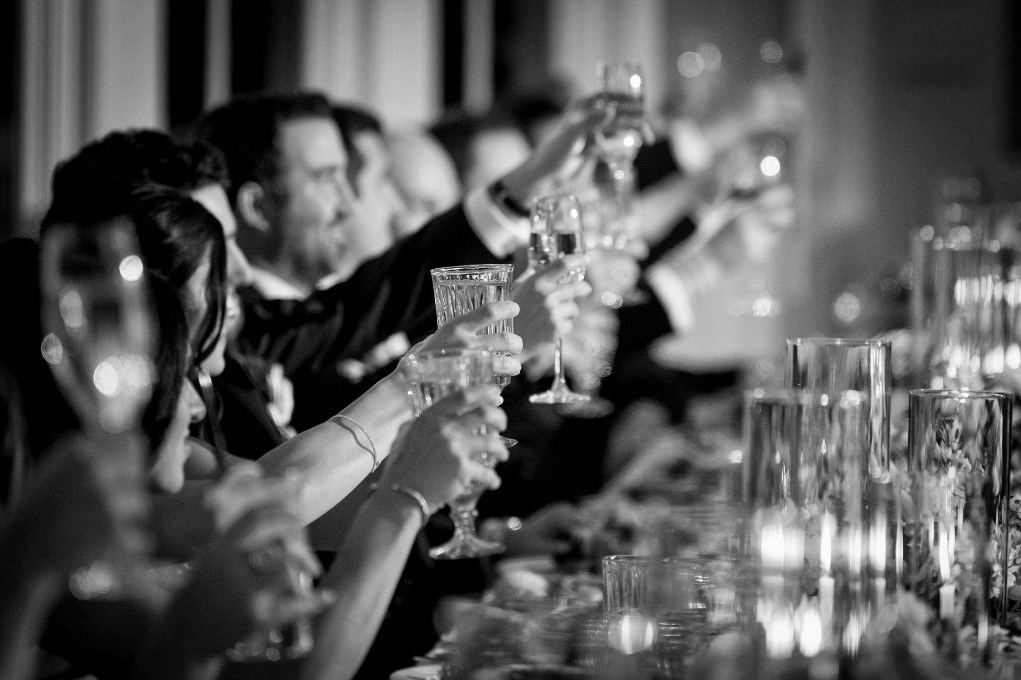 Glasses are raised during a wedding speech.