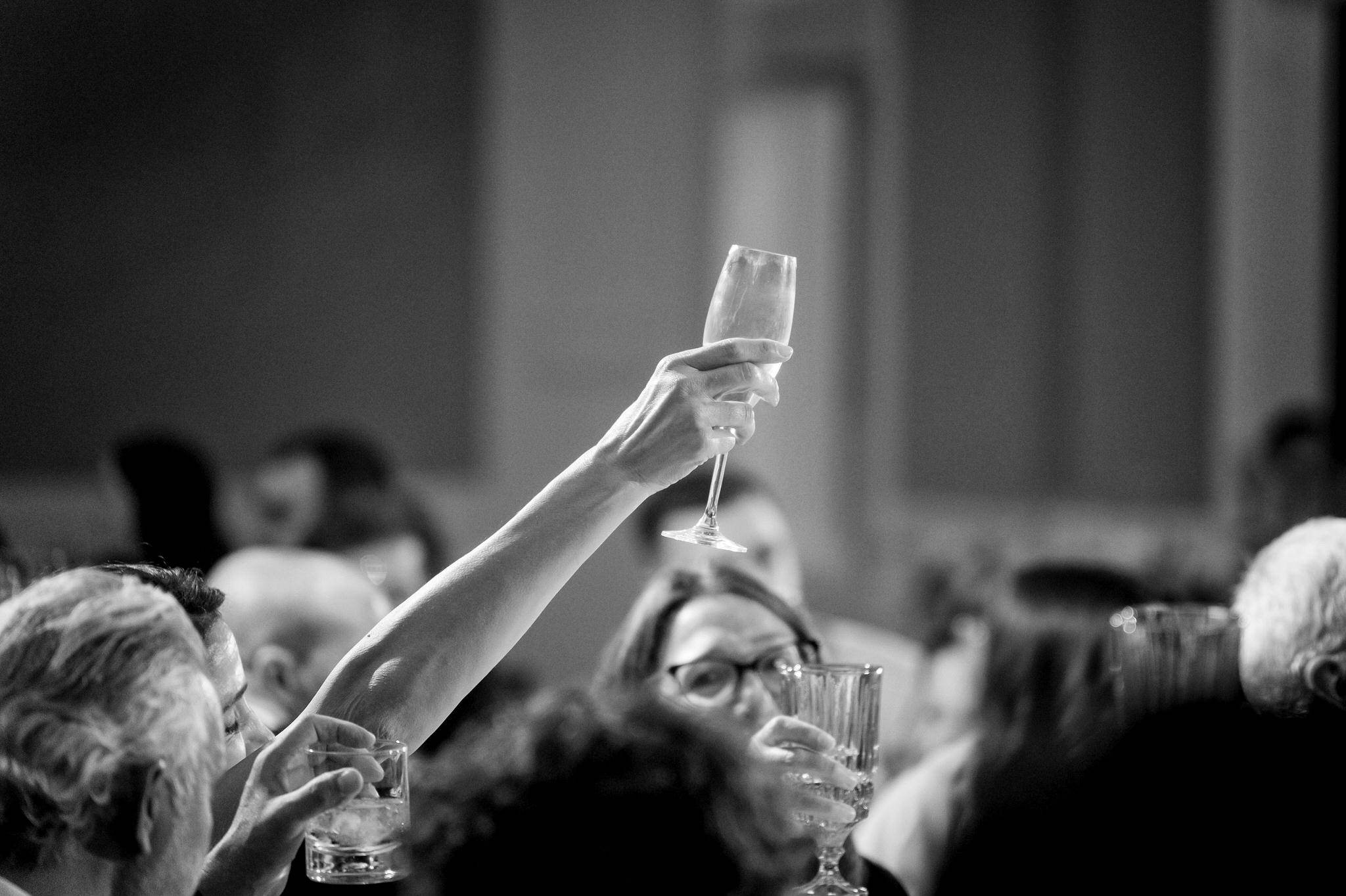 Guests raise a wine glass during wedding toasts.