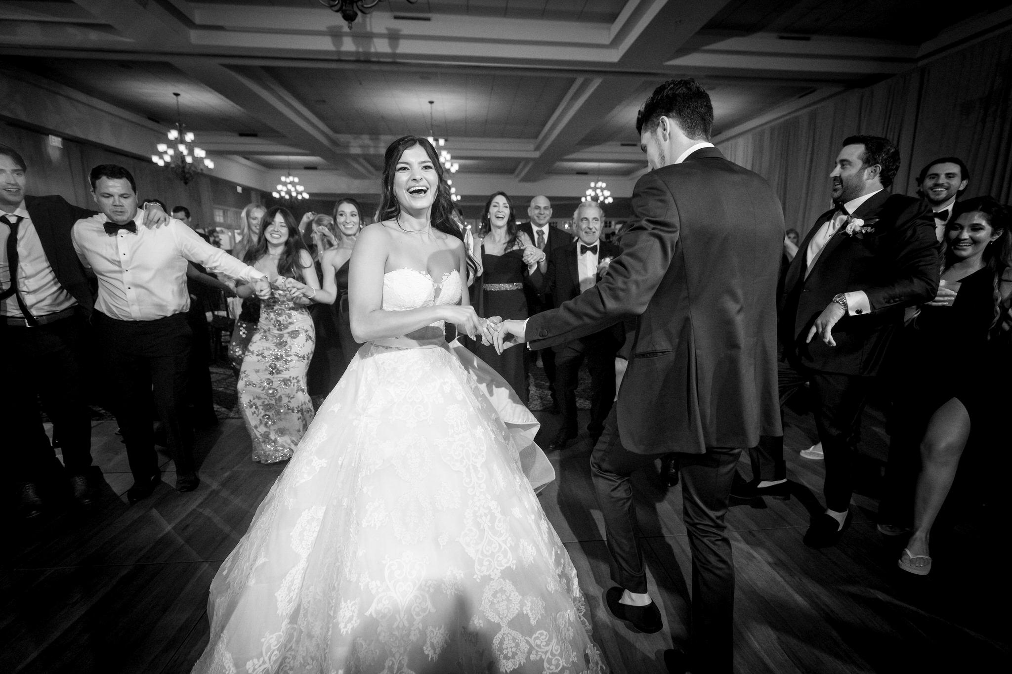 A bride and groom dance while surrounded by family at their wedding at Bay Harbor.  