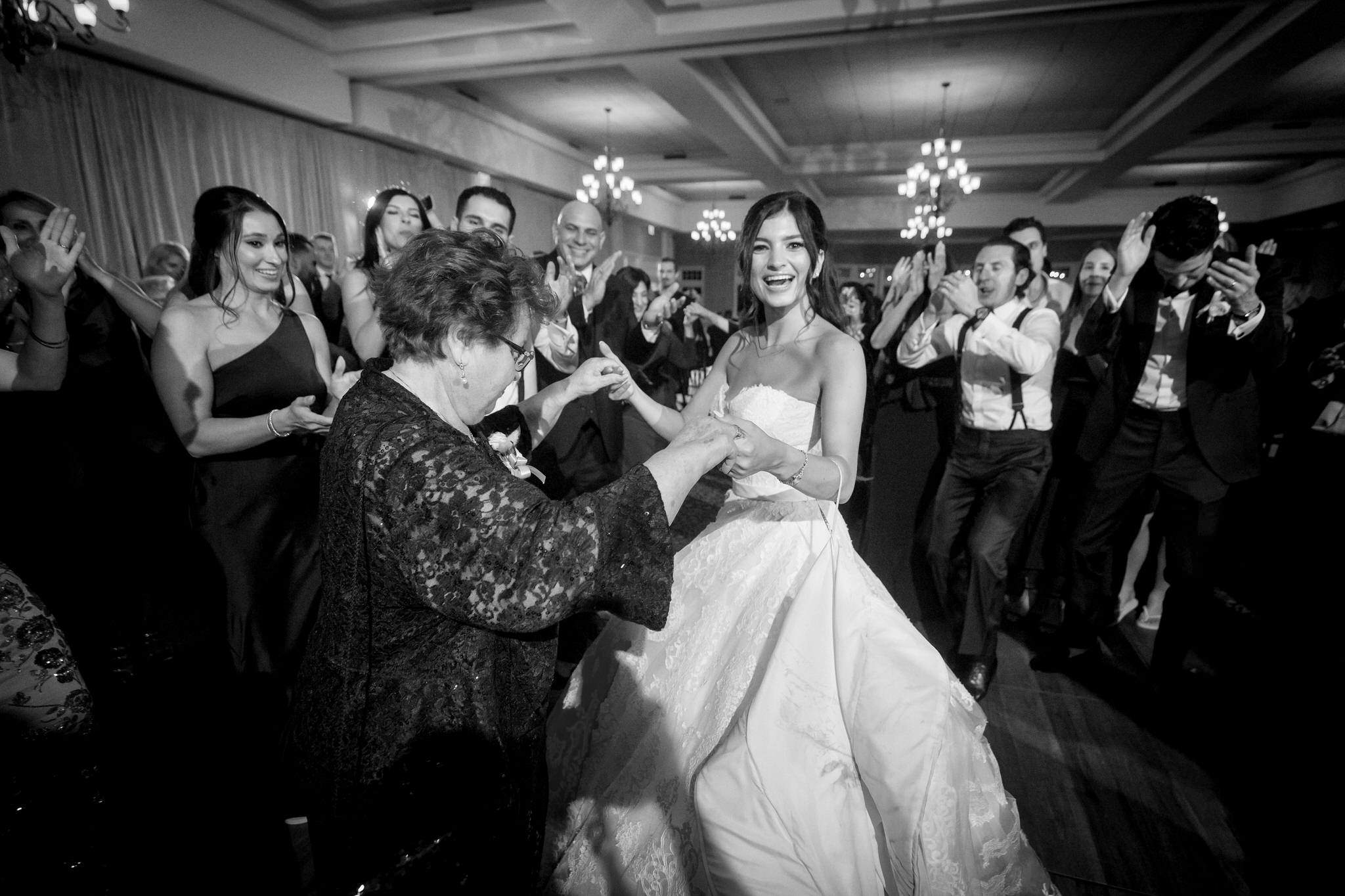 A bride dances with her grandma while surrounded by family at her wedding at Bay Harbor.  