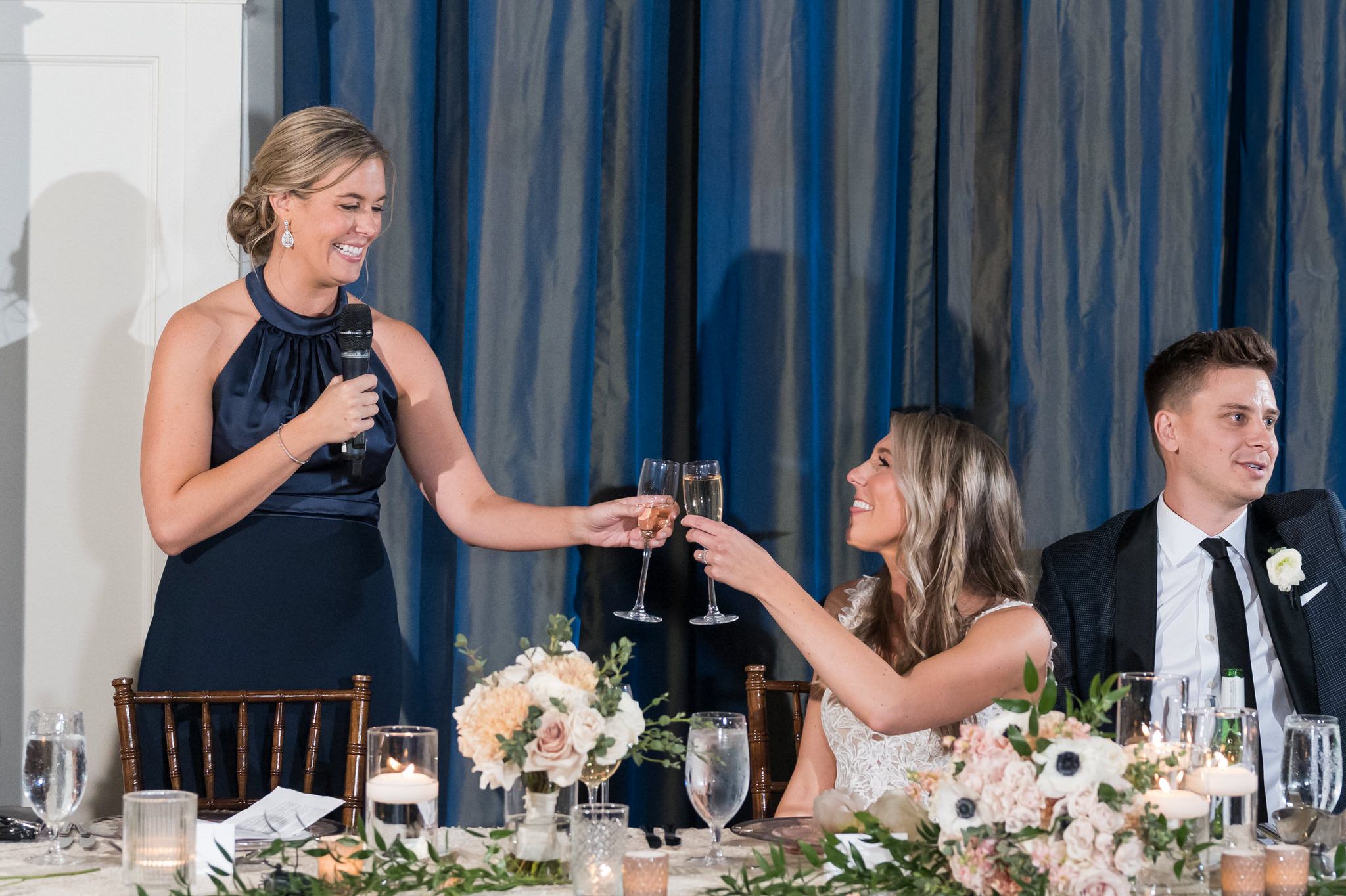 The bride and maid of honor toast glasses during a Westin Book Cadillac wedding.