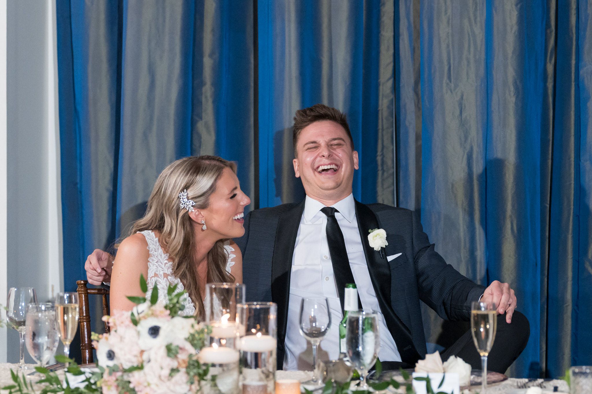 A groom laughs during speeches during his Westin Book Cadillac wedding reception.  