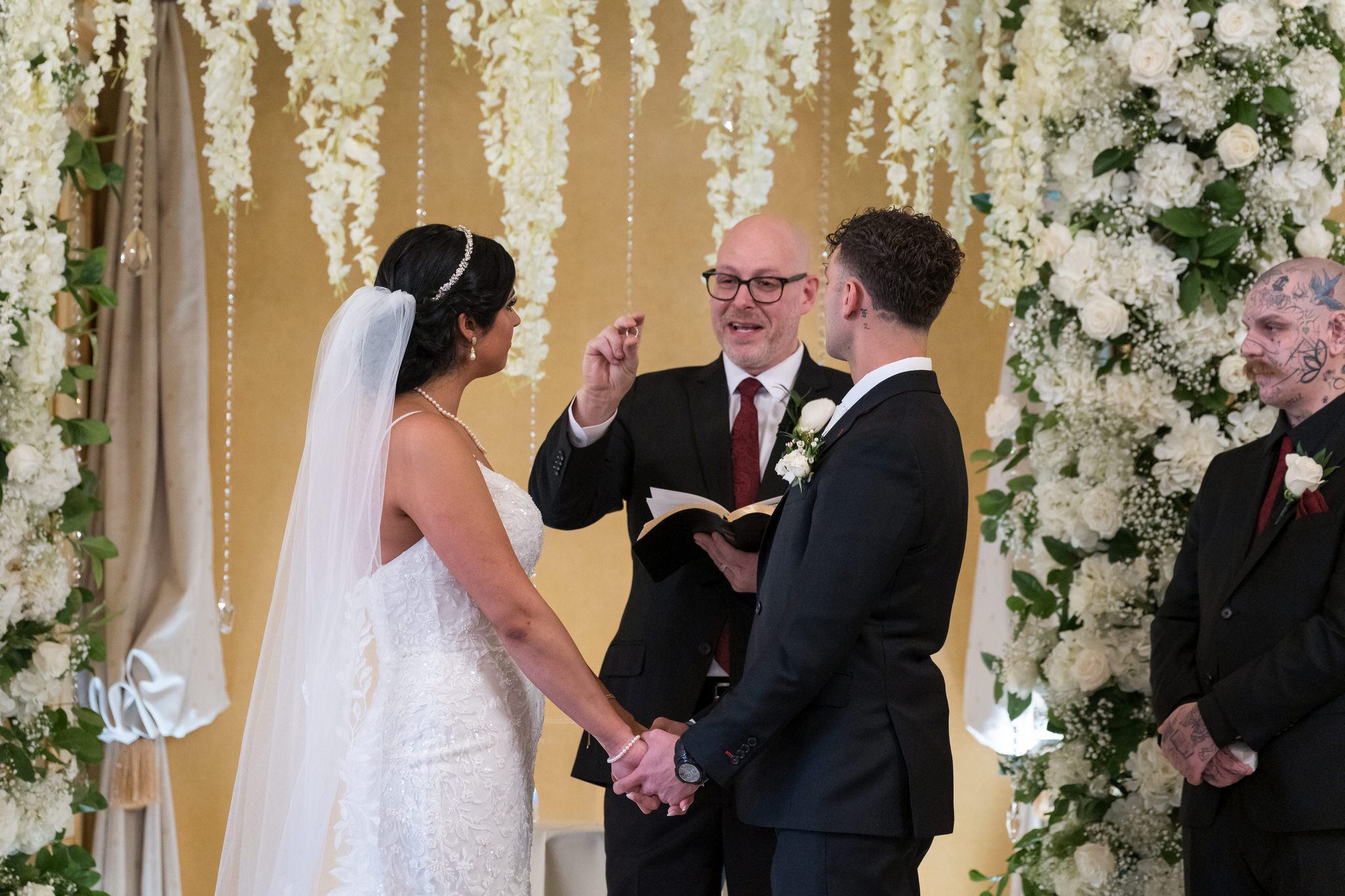 A bride and groom exchange vows at their Colony Club Detroit wedding ceremony. 