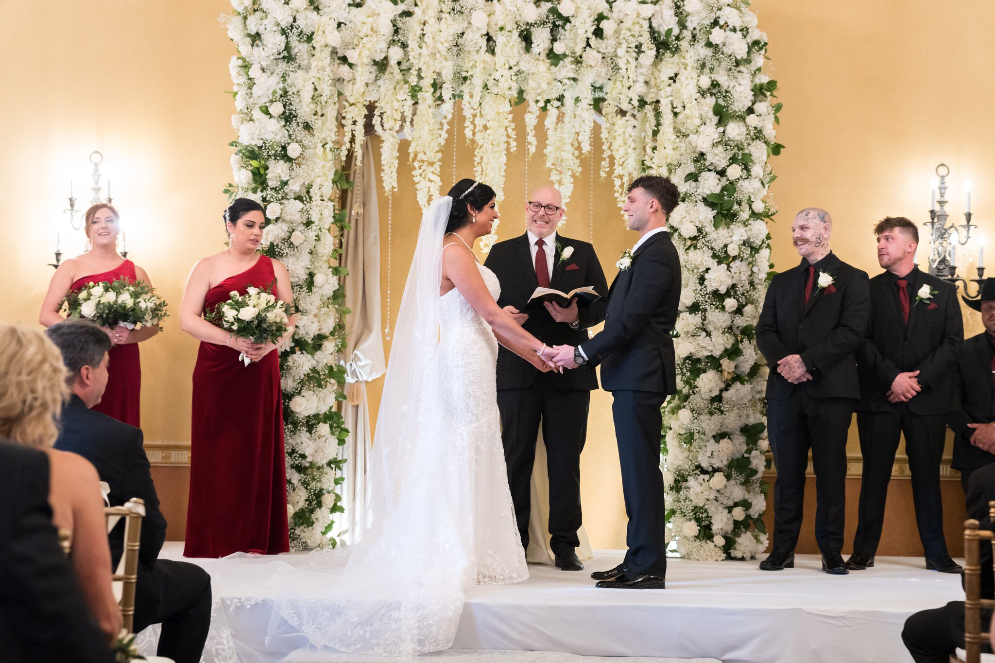 A bride and groom hold hands at their  Colony Club Detroit wedding ceremony. 