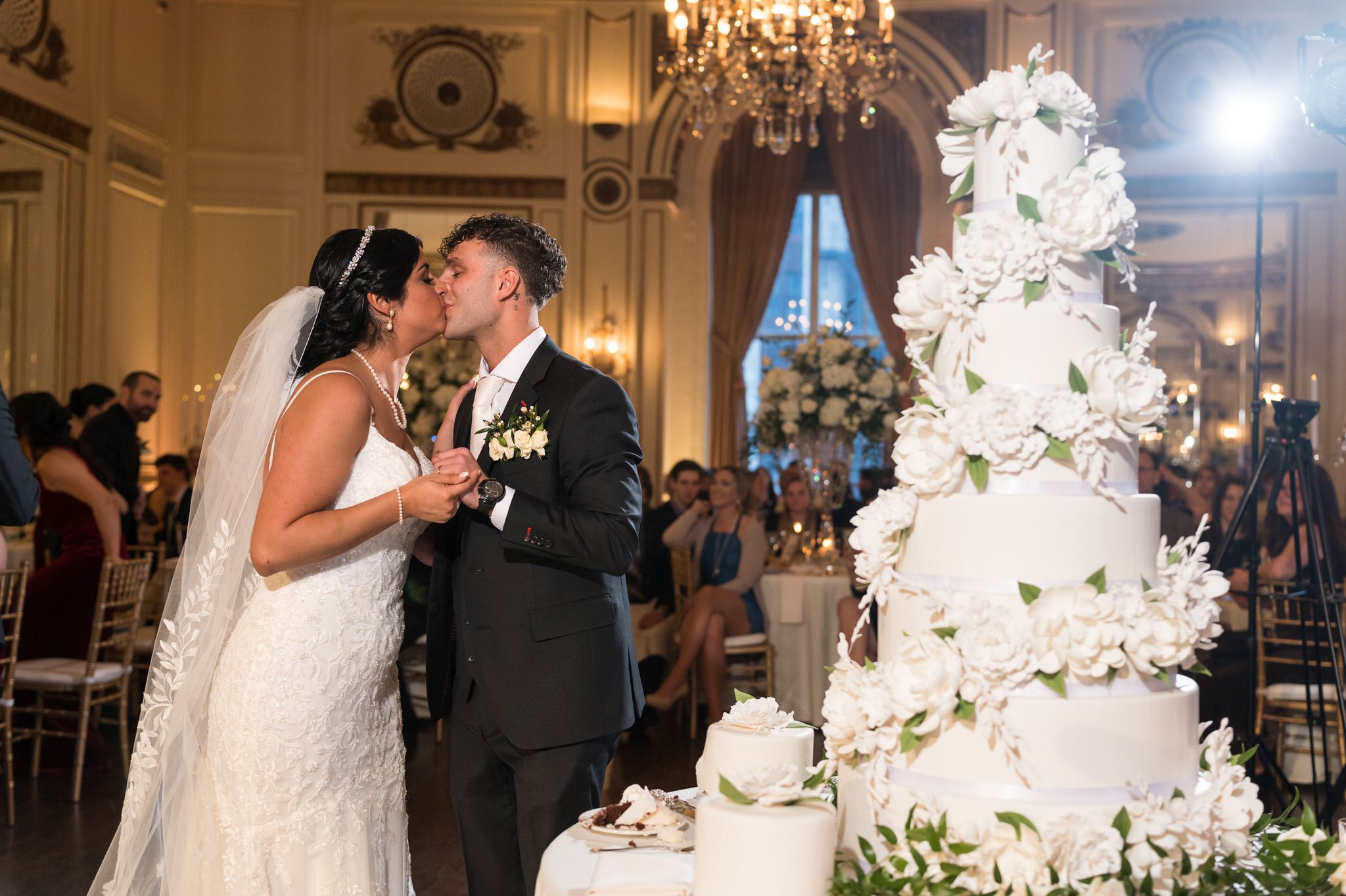 A couple kisses after cutting their wedding cake at their Colony Club Detroit wedding. 