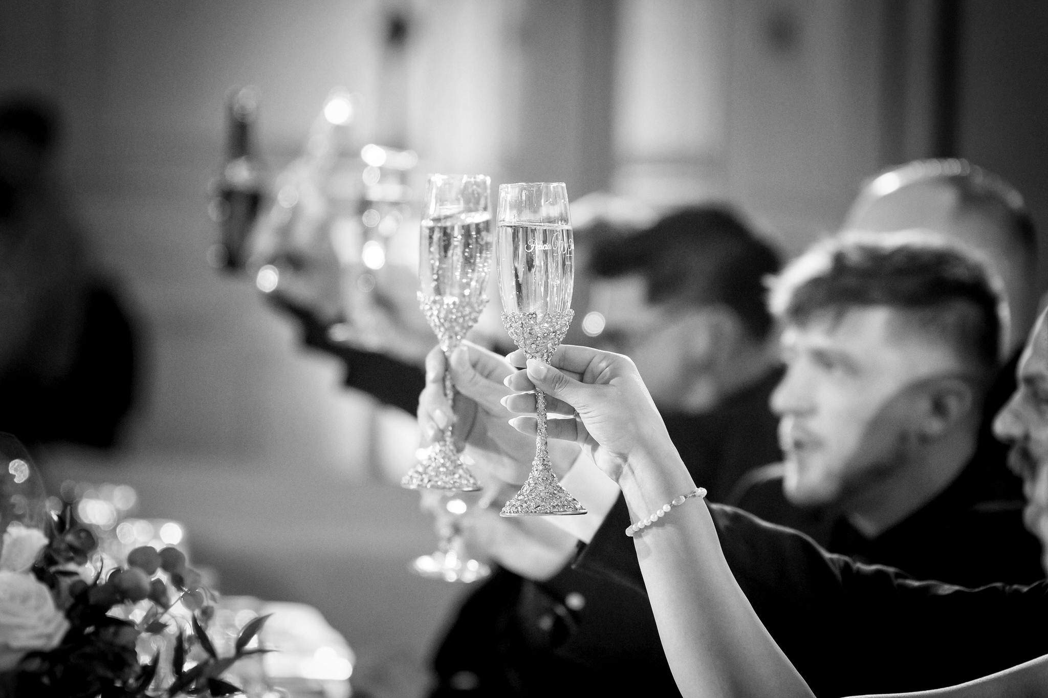Champagne glasses are raised during toasts at a Colony Club Detroit wedding. 