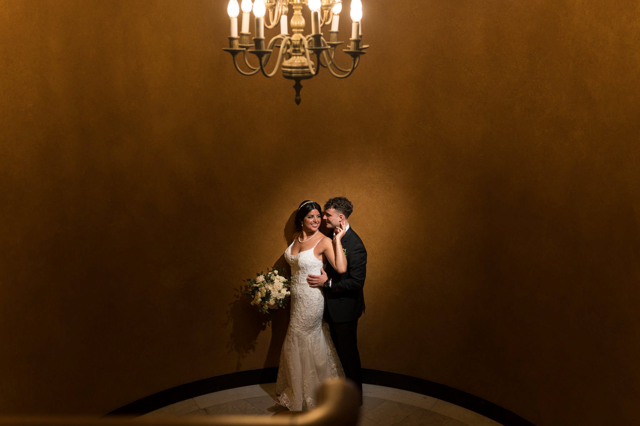A bride and groom pose for a portrait in the stairwell at their Colony Club Detroit wedding. 