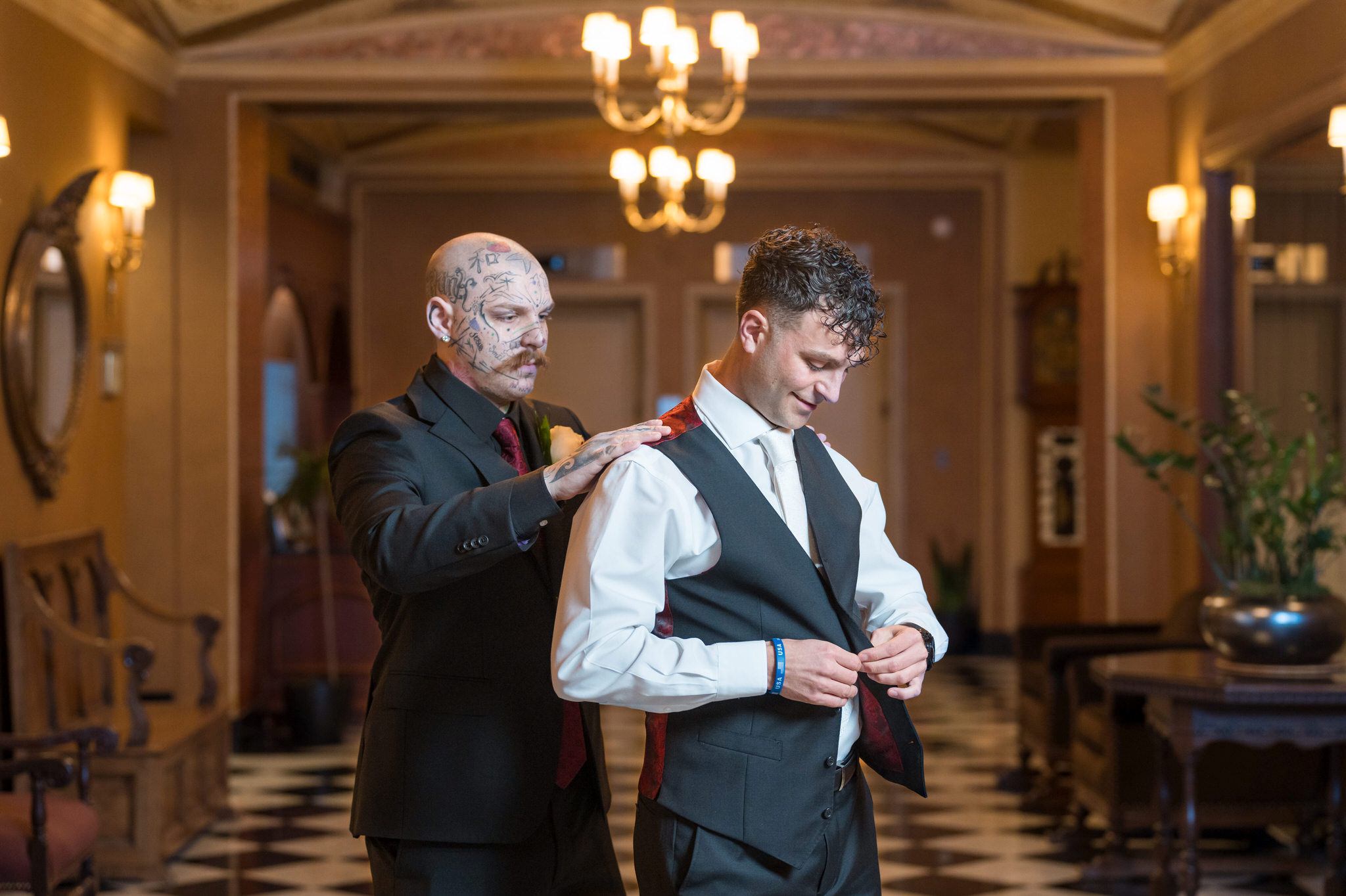 A groom puts on his vest on his wedding day in the lobby of the Colony Club in Detroit. 