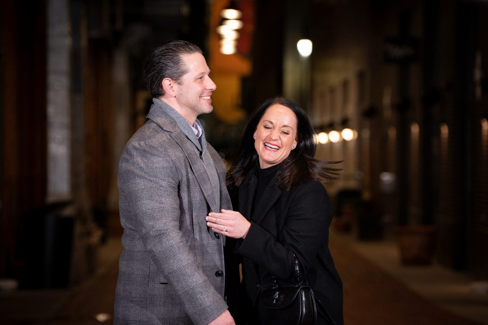 A fiance reacts and laughs after becoming engaged during a proposal in Parker's Alley.