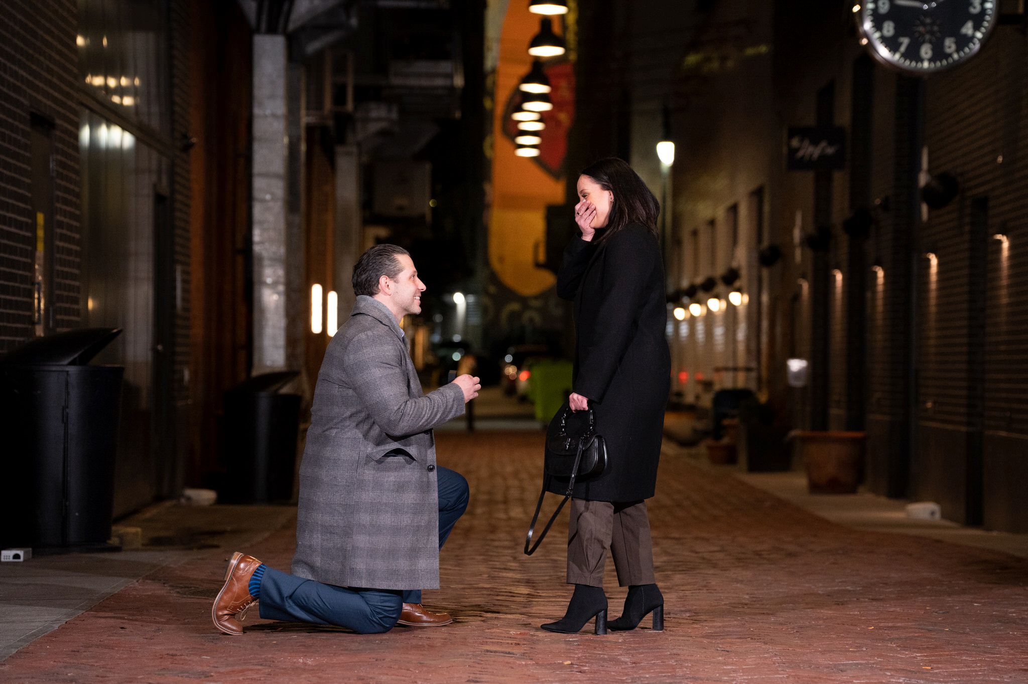 A woman reacts and covers her mouth during a proposal in Parker's Alley in Detroit.  