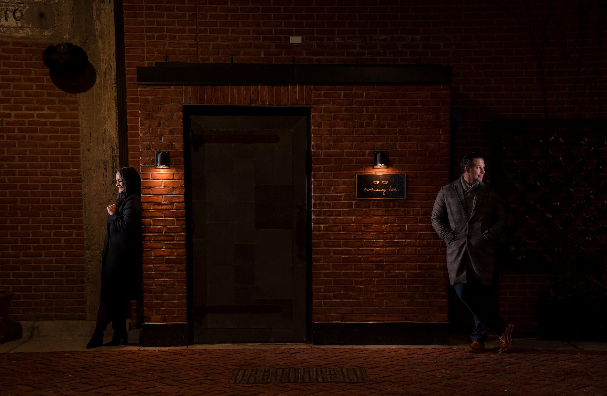 A couple leans on the entrance to the Evening Bar after their proposal in Parker's Alley.  