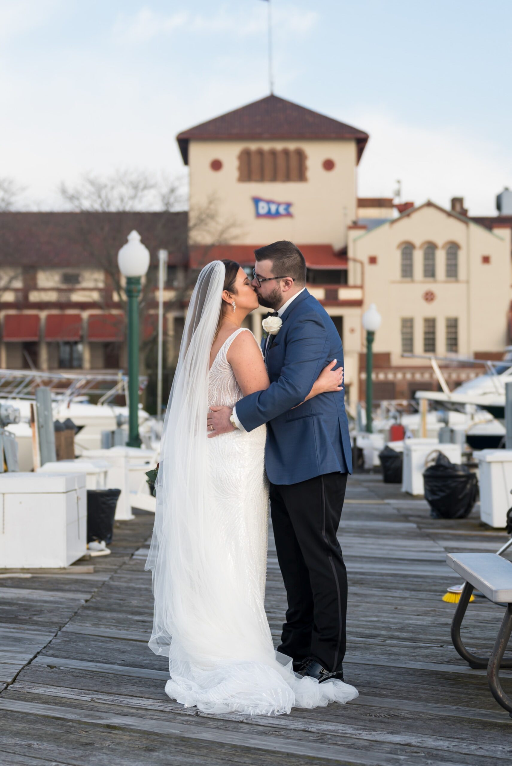 A bride and groom kiss on the docks during their Detroit Yacht Club wedding. 