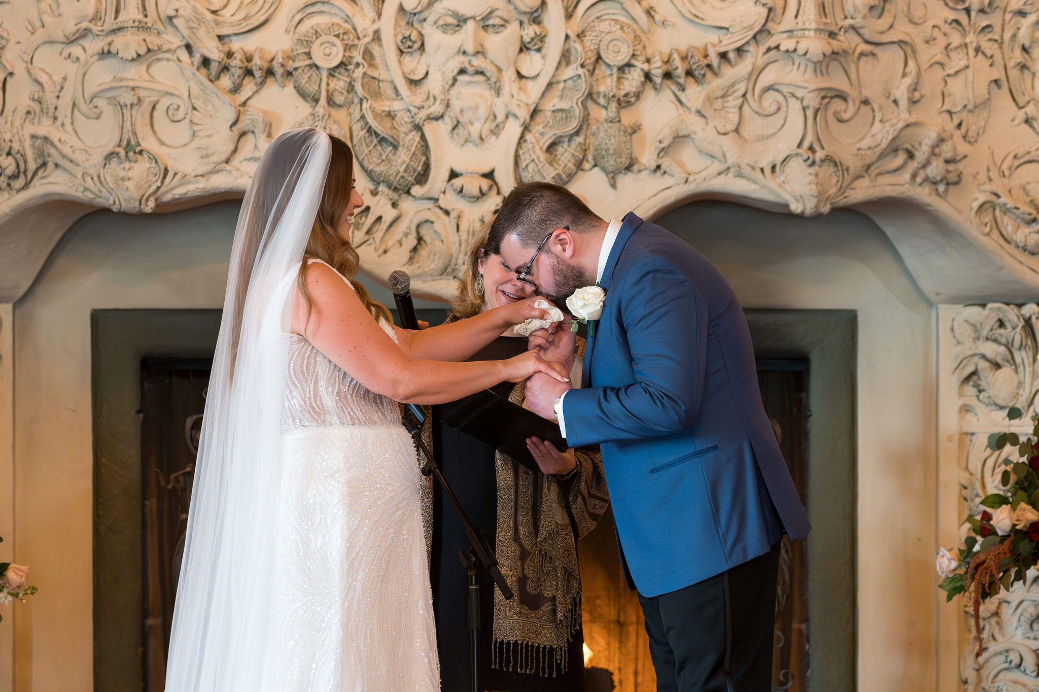 The groom kisses the hand of his bride at their Detroit Yacht Club wedding. 
