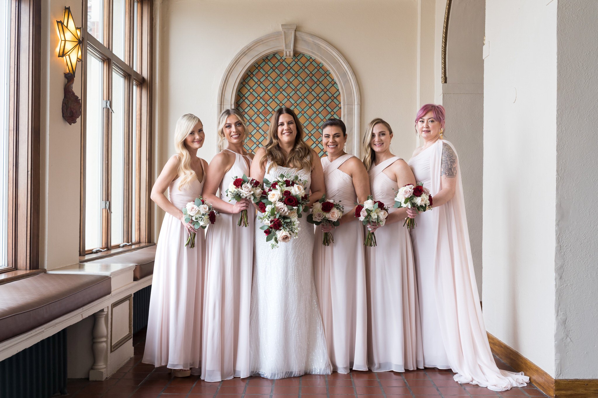 A bride and her bridesmaids pose for a portrait at their Detroit Yacht Club wedding.