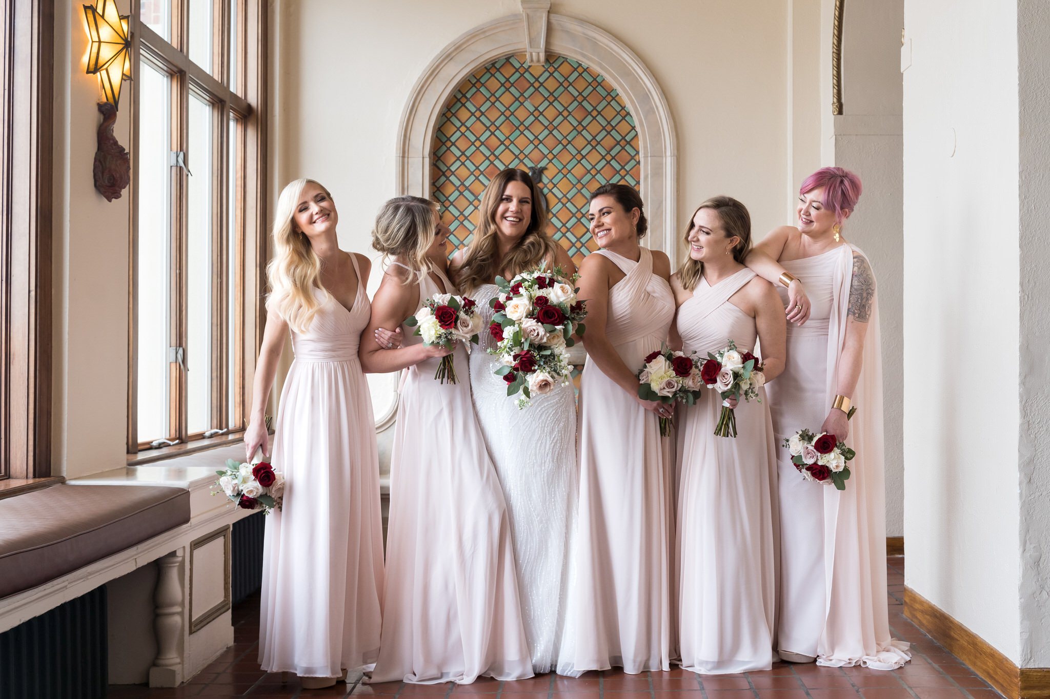 A bride and her bridesmaids pose for a portrait at their Detroit Yacht Club wedding.