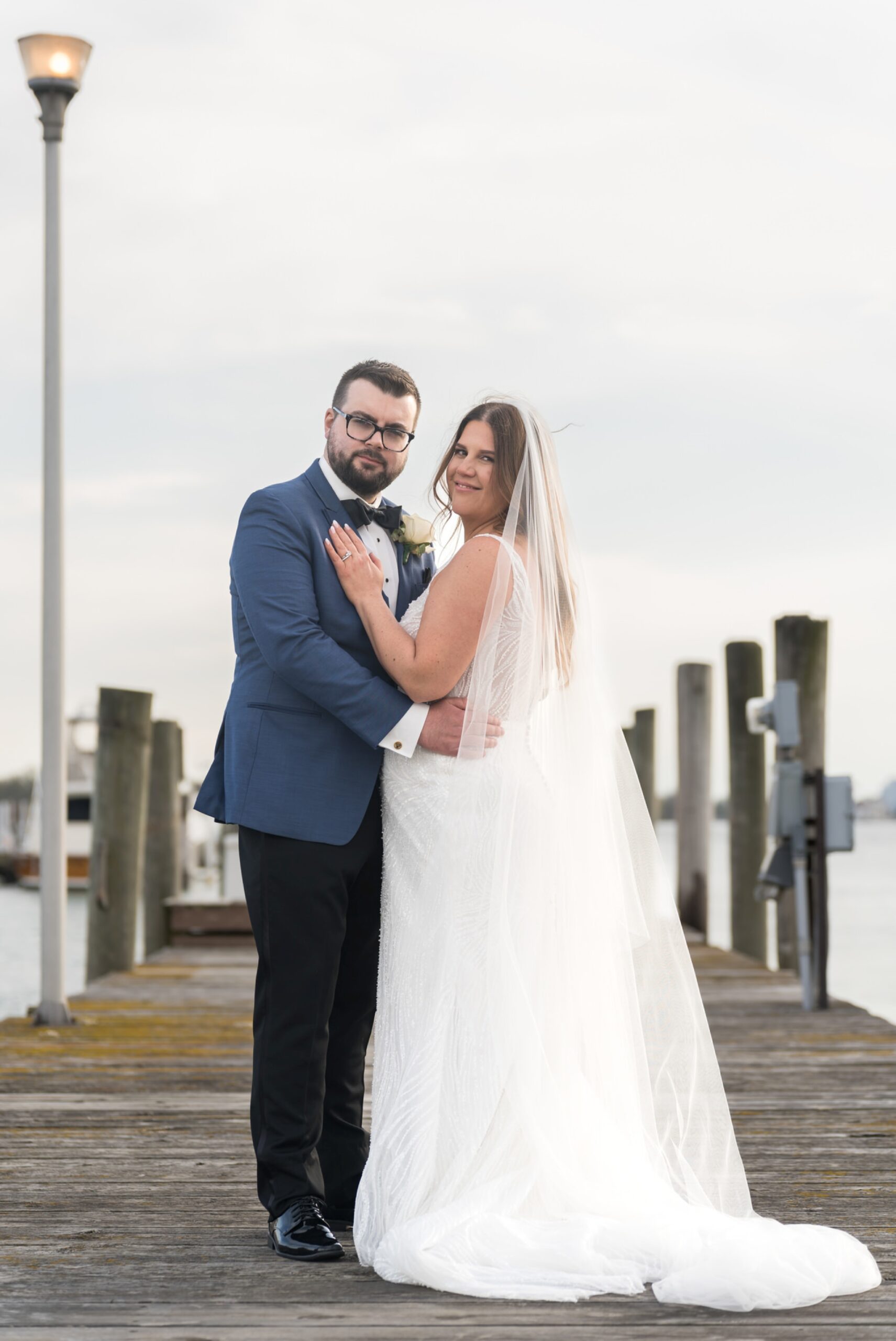 A bride and groom pose on the docks during their Detroit Yacht Club wedding. 