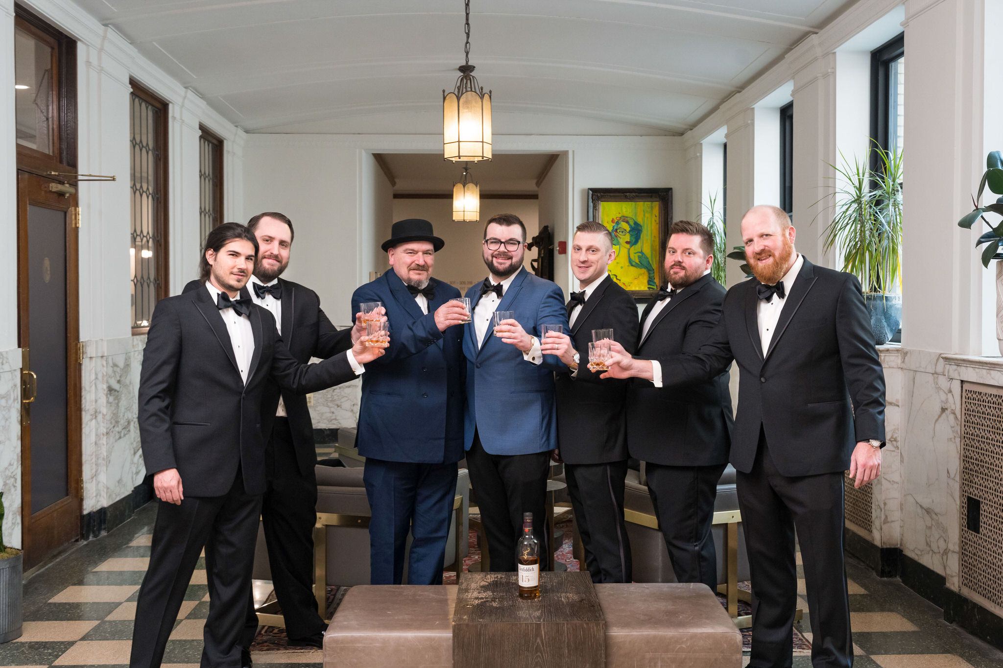 Groomsmen toast to the groom in the lobby of the Foundation Hotel. 