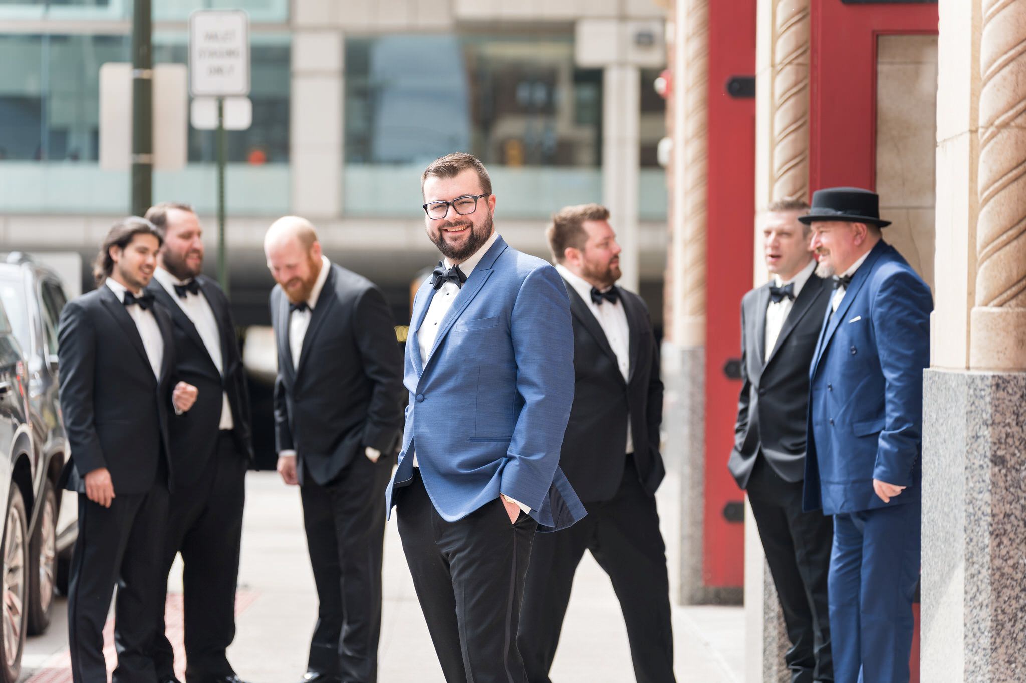 A groom and his groomsmen stand outside of the Foundation Hotel. 