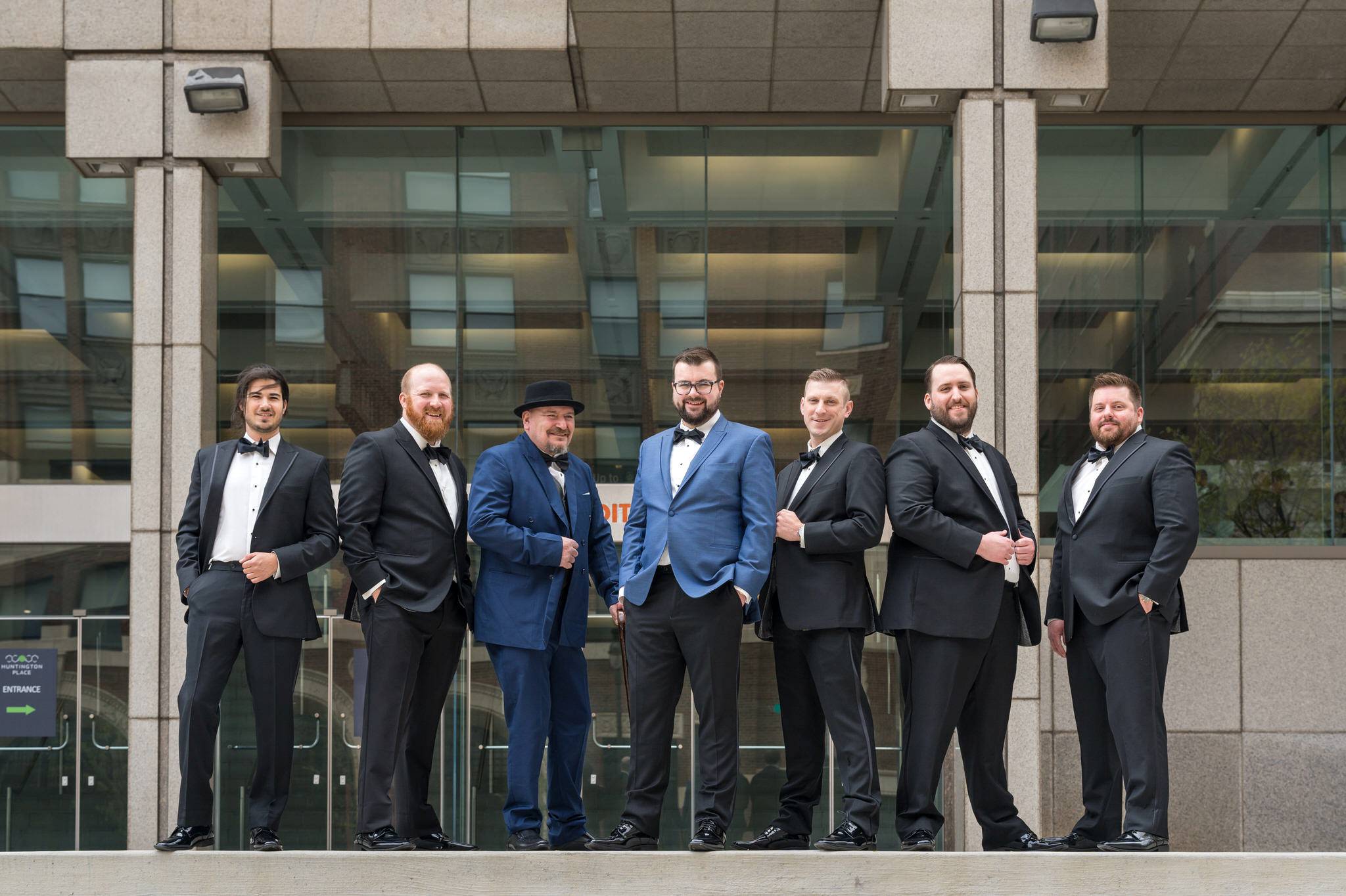 A groom and his groomsmen pose on the steps outside of the Foundation Hotel. 