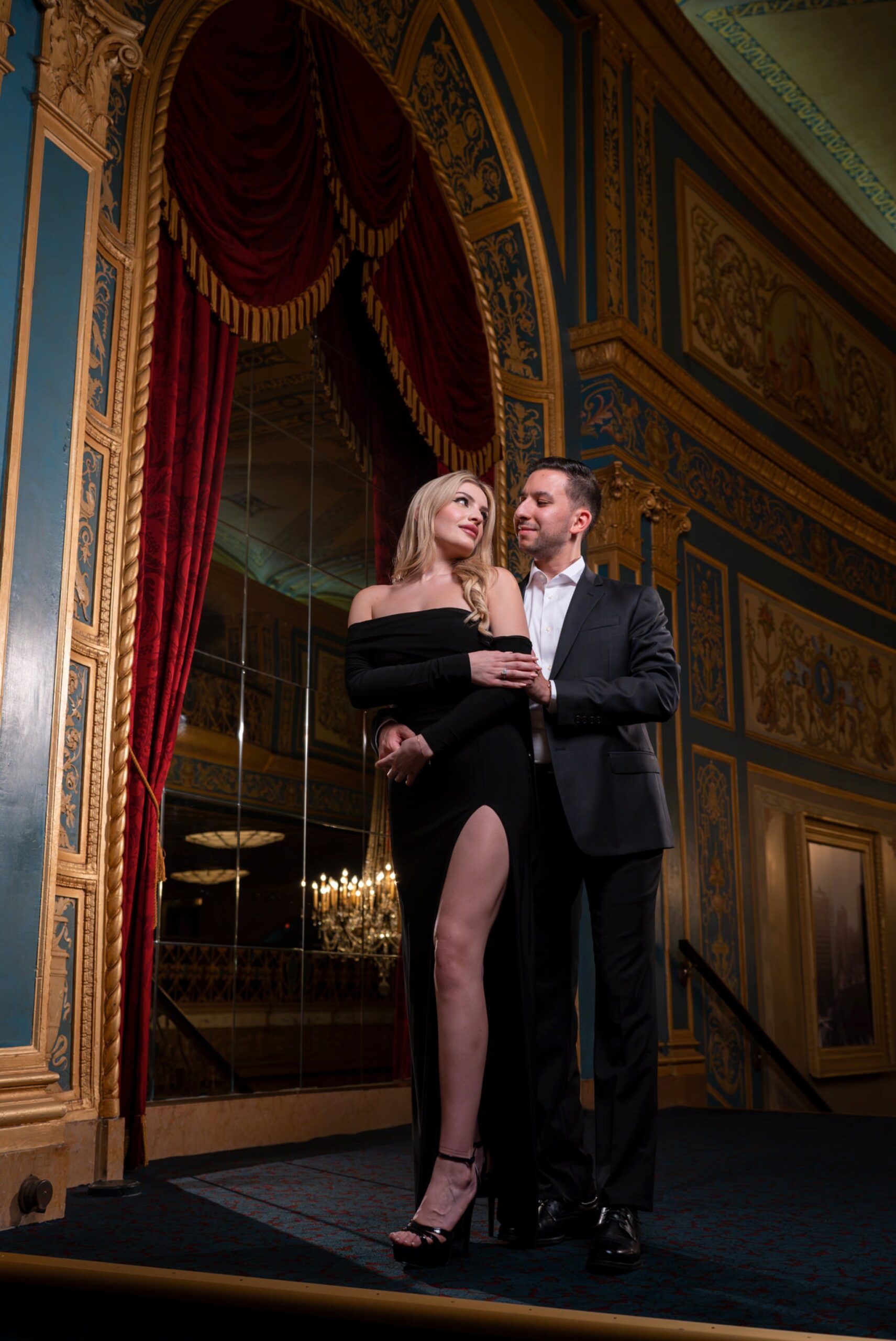 A guy hugs his fiance from behind at their proposal at Detroit Opera House.
