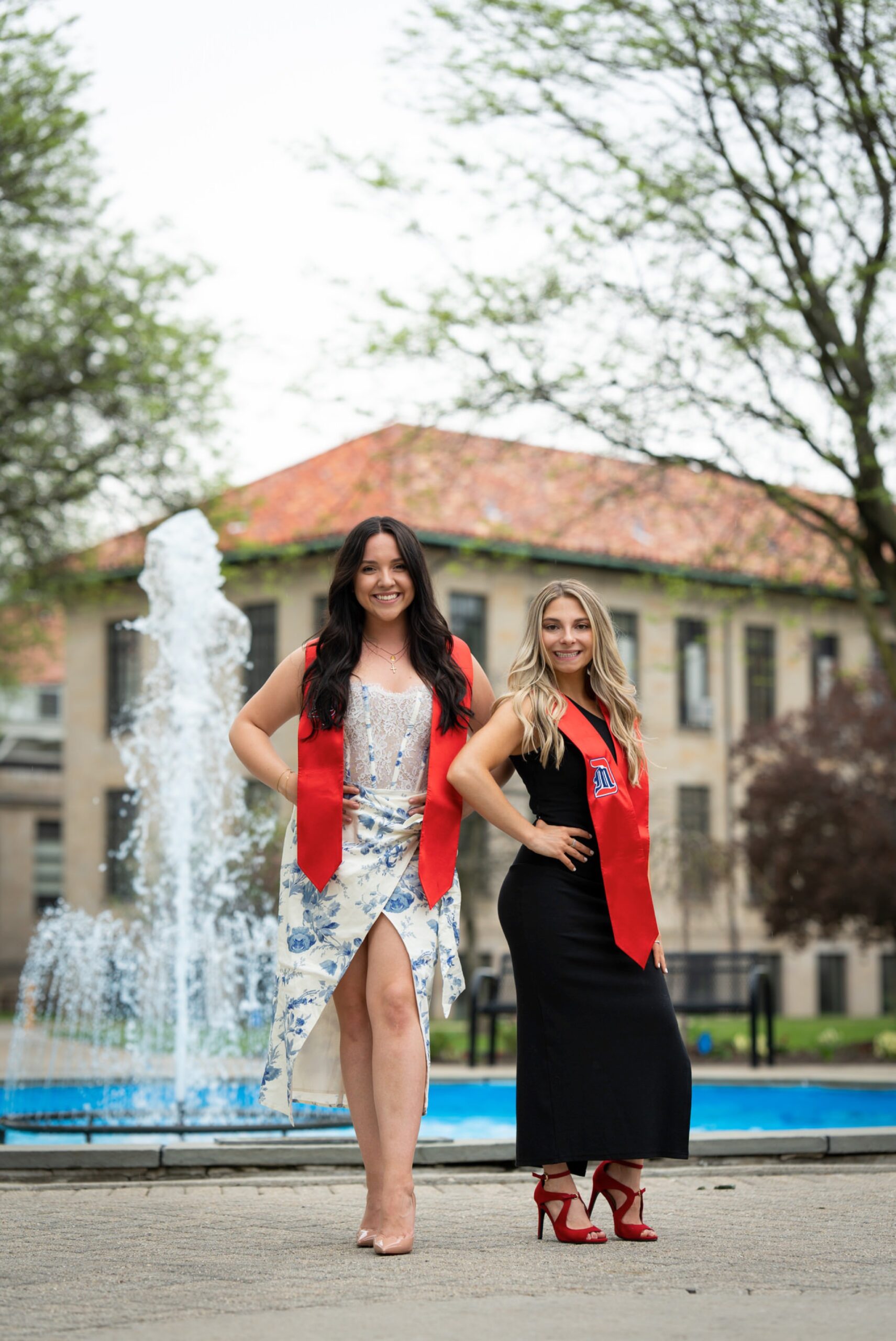 Girls pose in front of a fountain on U of D Mercy's campus for college graduation photos.