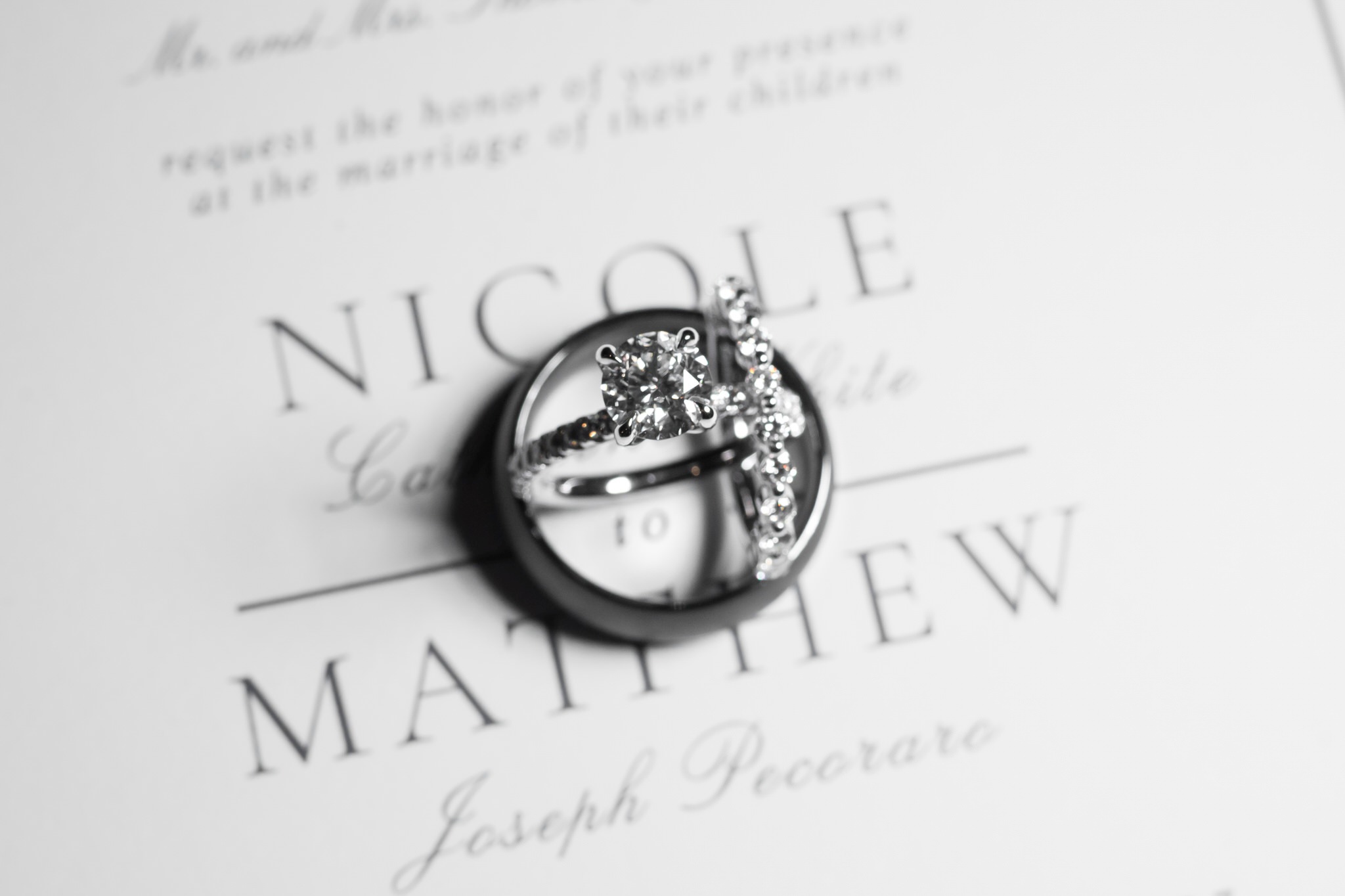 Wedding rings sit on top of an invite.