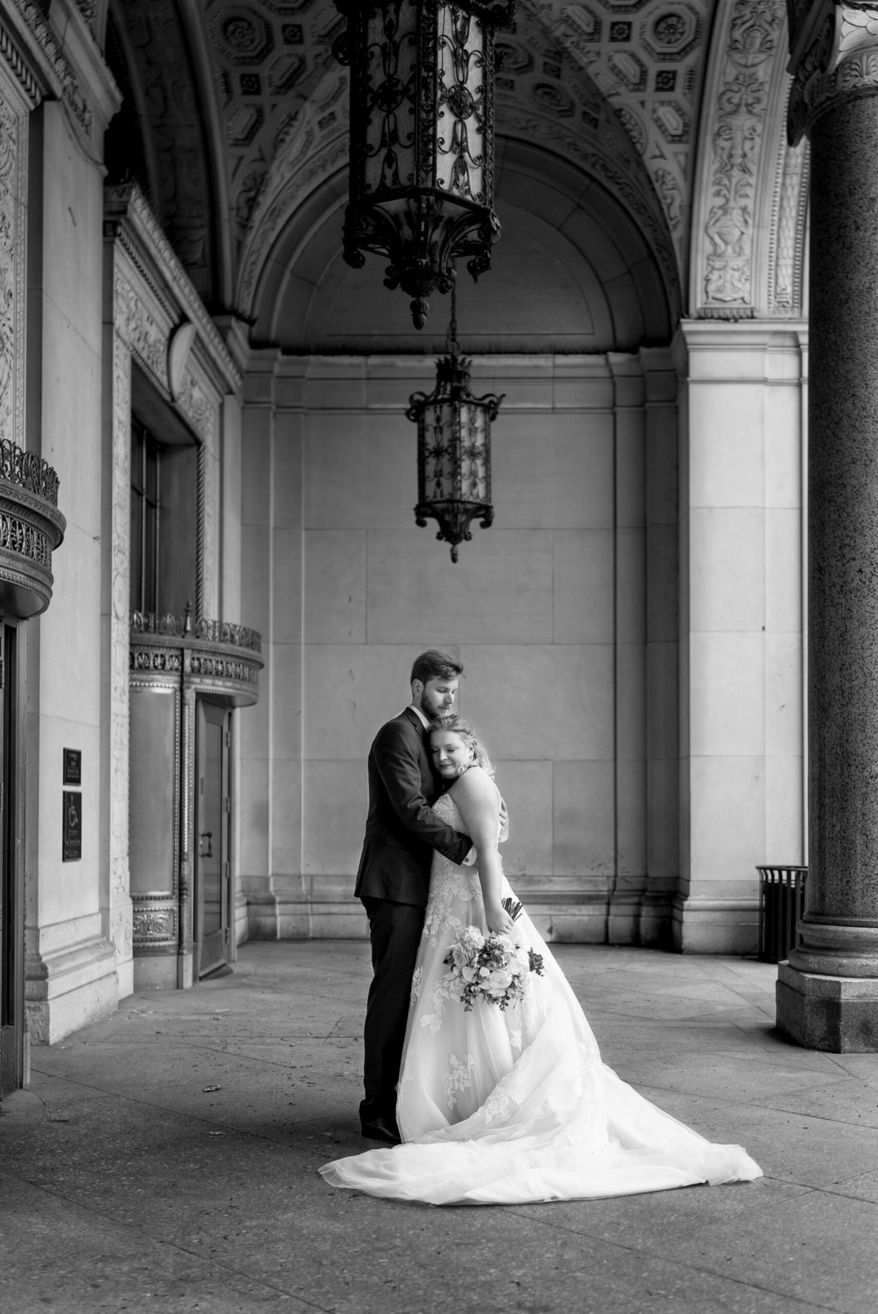 A couple embrace in a quiet moment on their wedding day at the Cadillac Place Apartments.  