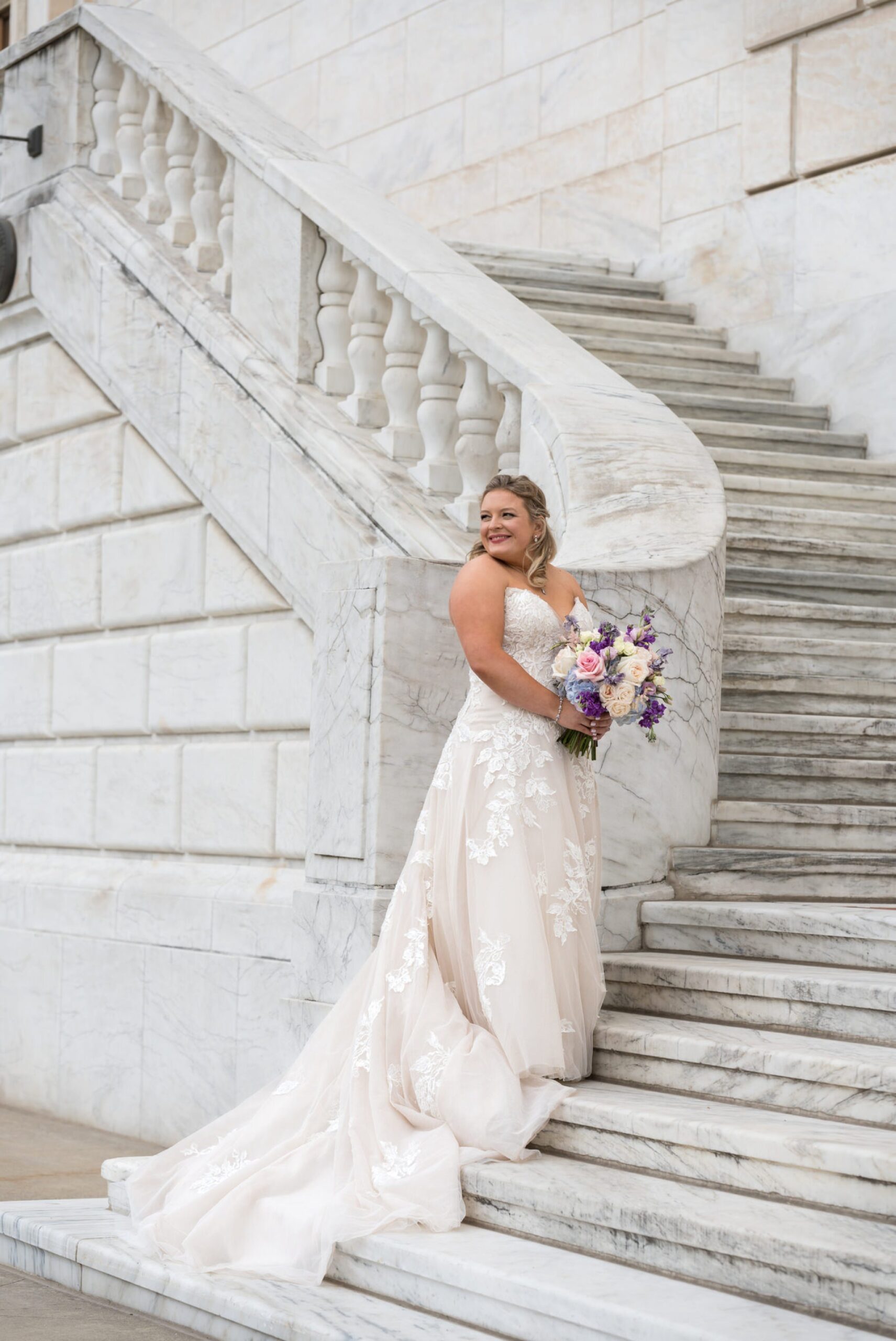 A bride poses on the steps of the Detroit Institute of Art.  