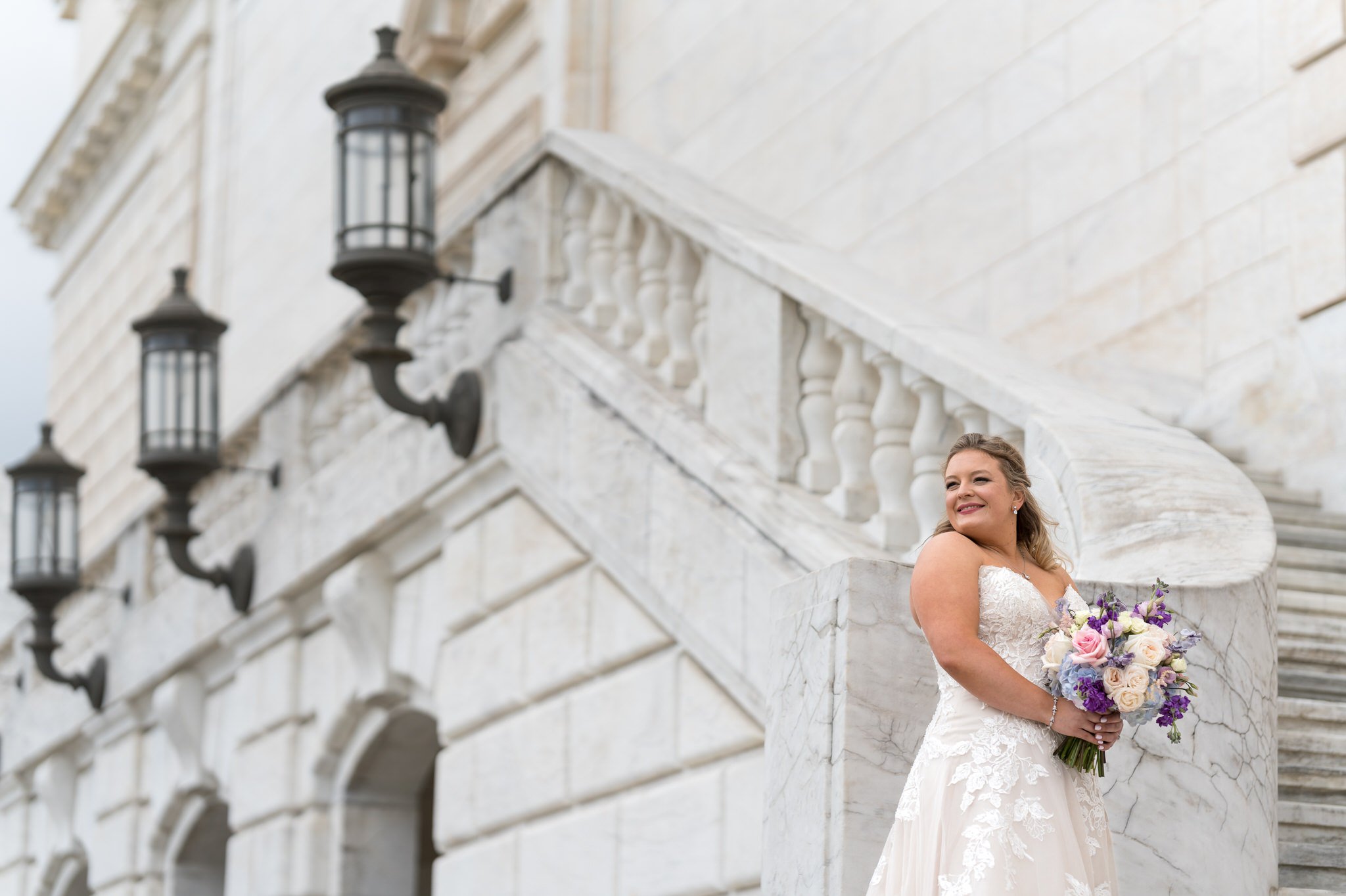 A bride poses on the steps of the Detroit Institute of Art.  