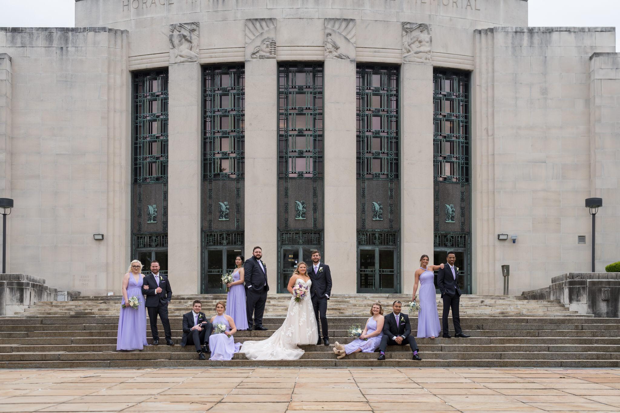 A bridal party pose on the steps of the Horace H. Rackham Educational Memorial on their wedding day.  