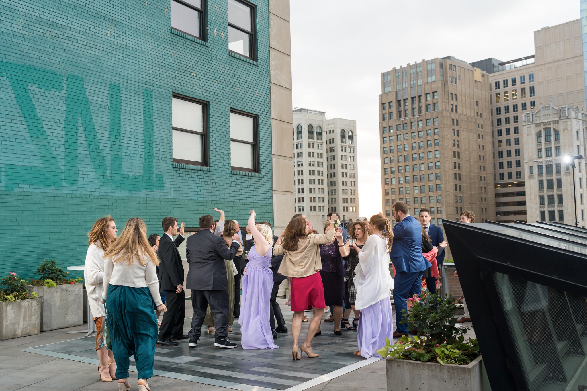 Guests dance on the rooftop dance floor at a Madison Building wedding in Detroit.  