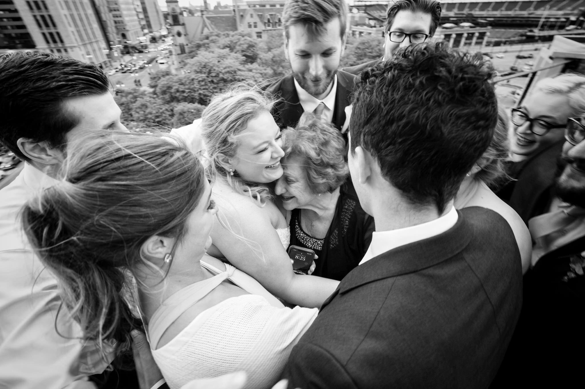 Family surrounds grandma in a candid moment at a Madison Building wedding in Detroit.  