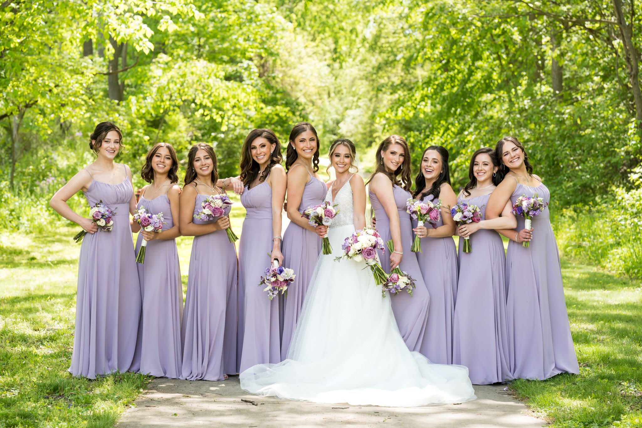 Wearing lavender colored dresses, bridesmaids pose for a picture at Van Hoosen Museum. 