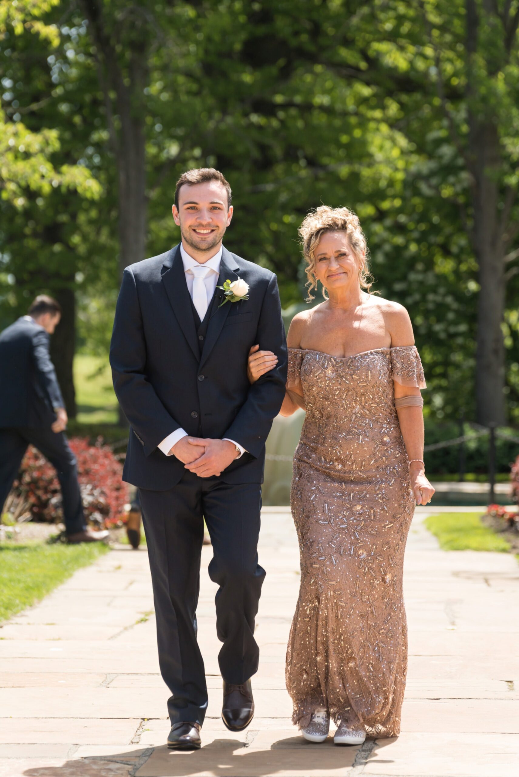 The groom and his mom walk down the aisle at his wedding at Meadowbrook Hall.