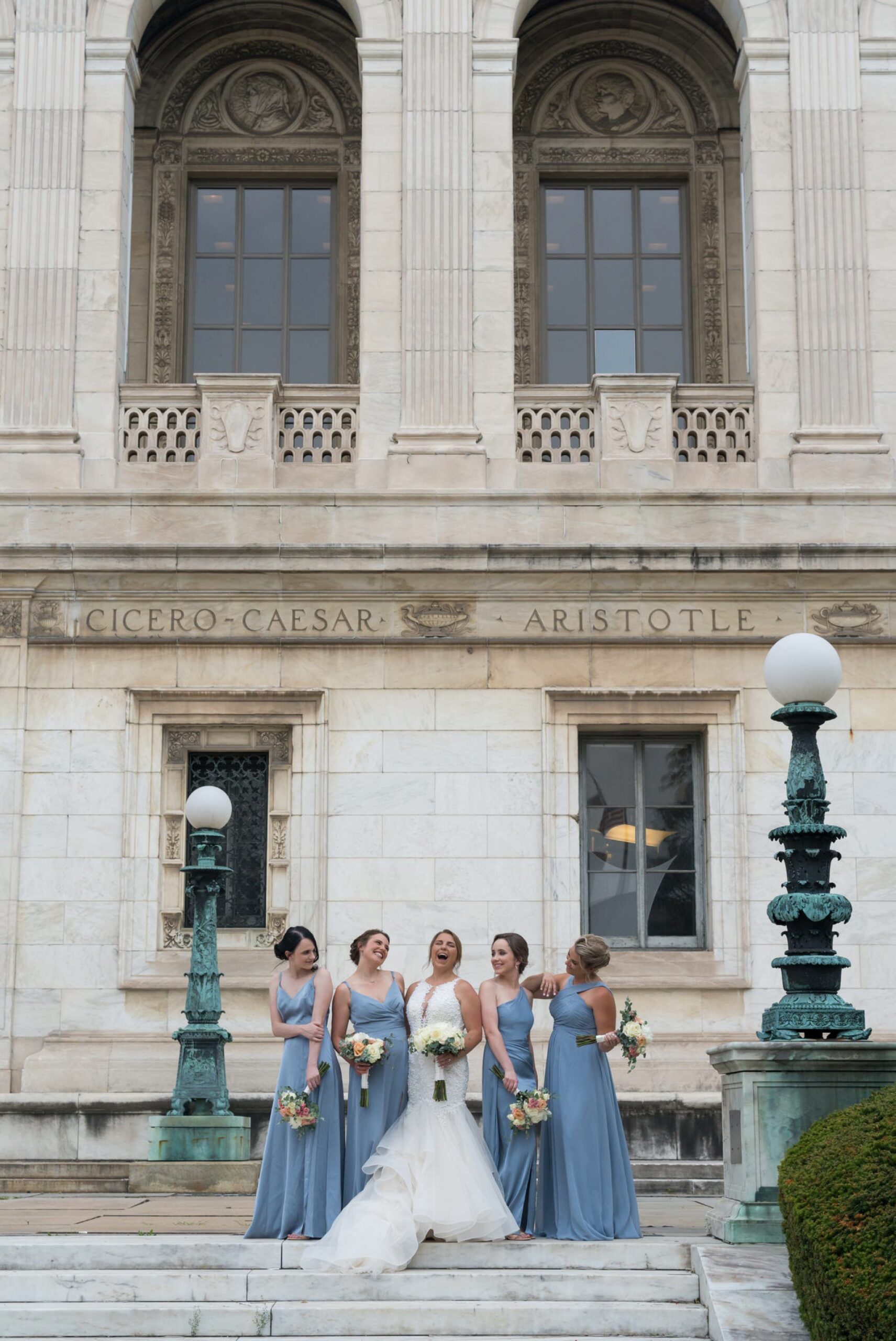 Bridesmaids, wearing pastel blue dresses, pose for formals at Detroit Public Library.