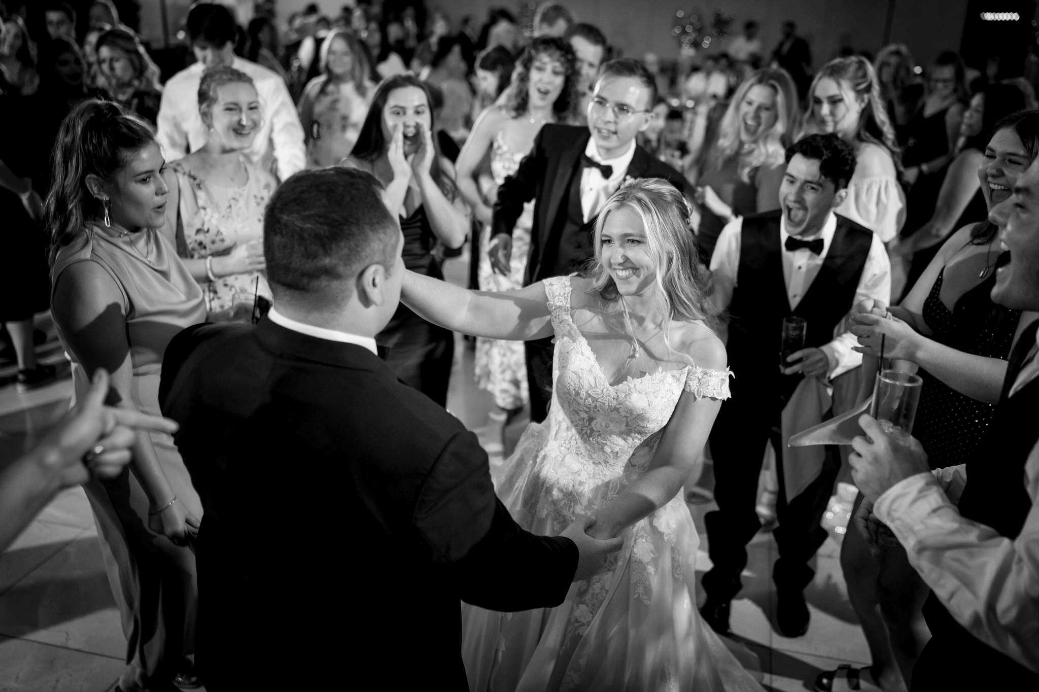 The bride and groom dance surrounded by guests at a wedding reception at the Italian American Cultural Society. 