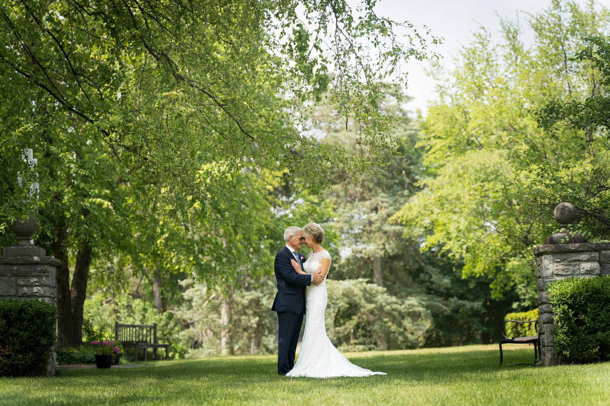 A couple embraces on the back lawn before their Kirk in the Hills wedding.  